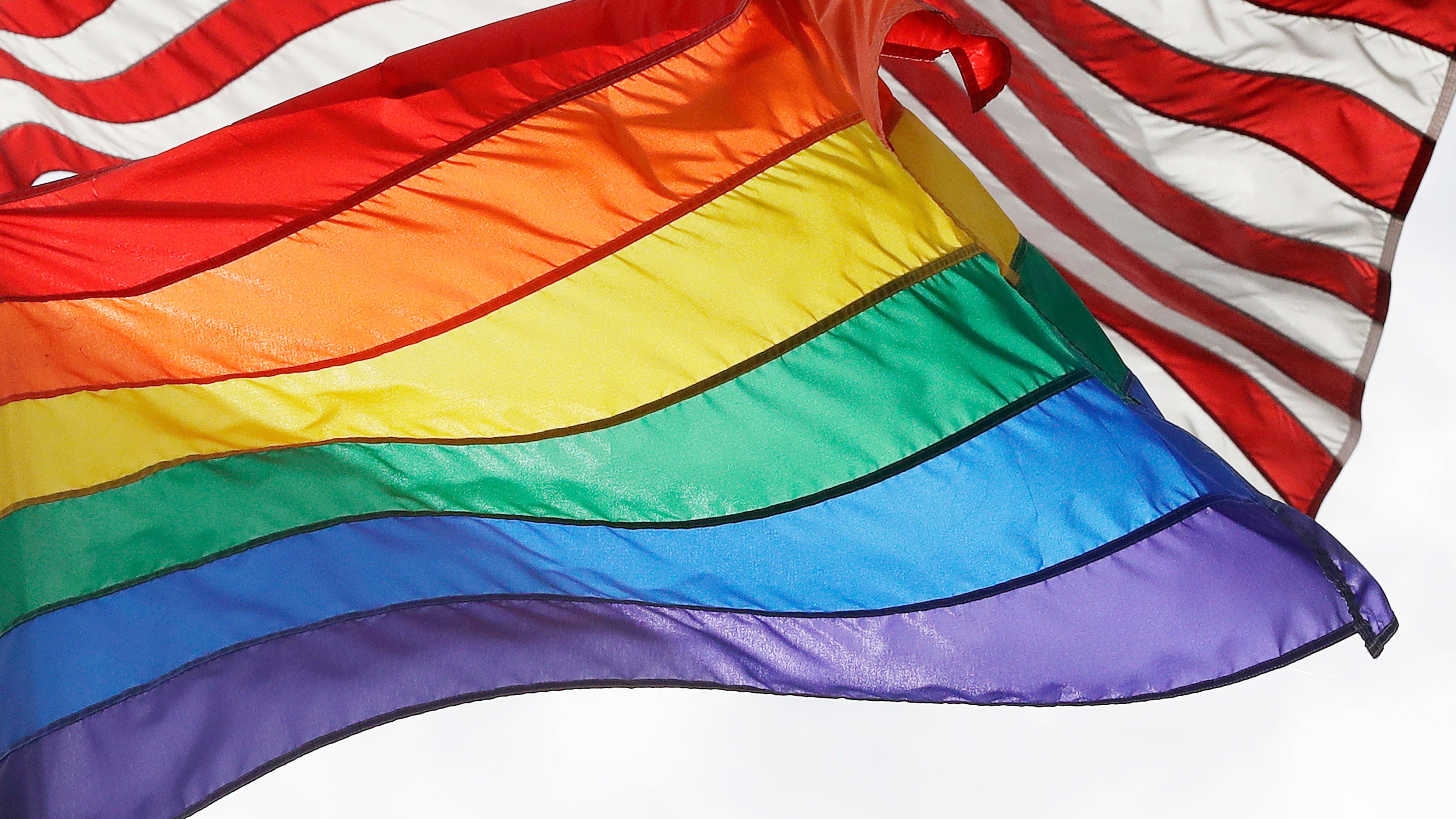 FILE - An LGBTQ+ pride flag flies beneath a U.S. flag at the Stonewall National Monument in New York, on Oct. 11, 2017. (AP Photo/Mark Lennihan, File)