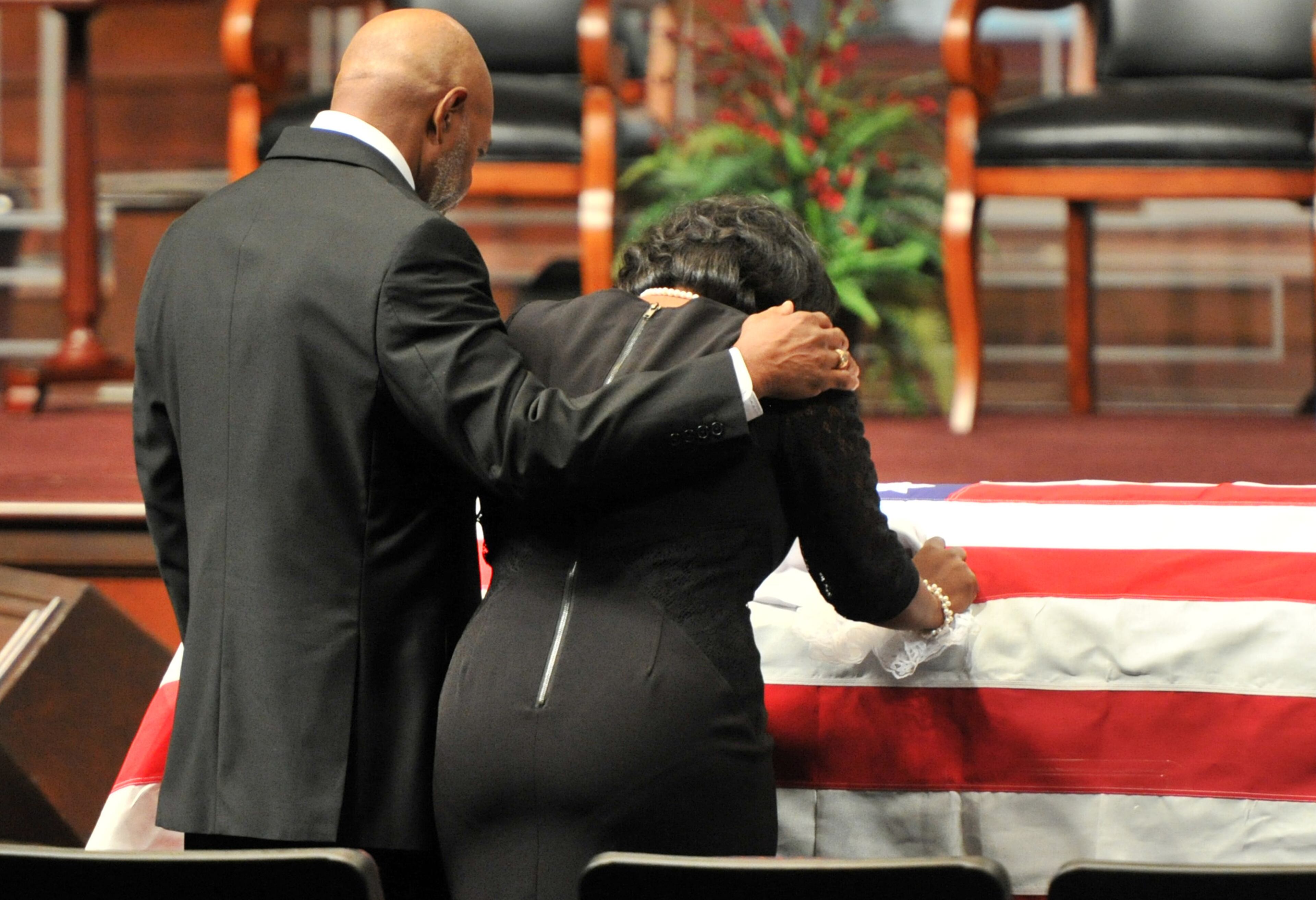 Terra Smiley (right), widow, touches the casket as her father Thomas Jones comforts her during APD Officer Shawn Smiley's funeral at First Baptist Church of Atlanta on Saturday, November 10, 2012. APD Officer Shawn Smiley was in the passenger seat last weekend when an APD helicopter searching for a missing 9-year-old boy crashed in Atlanta. HYOSUB SHIN / HSHIN@AJC.COM