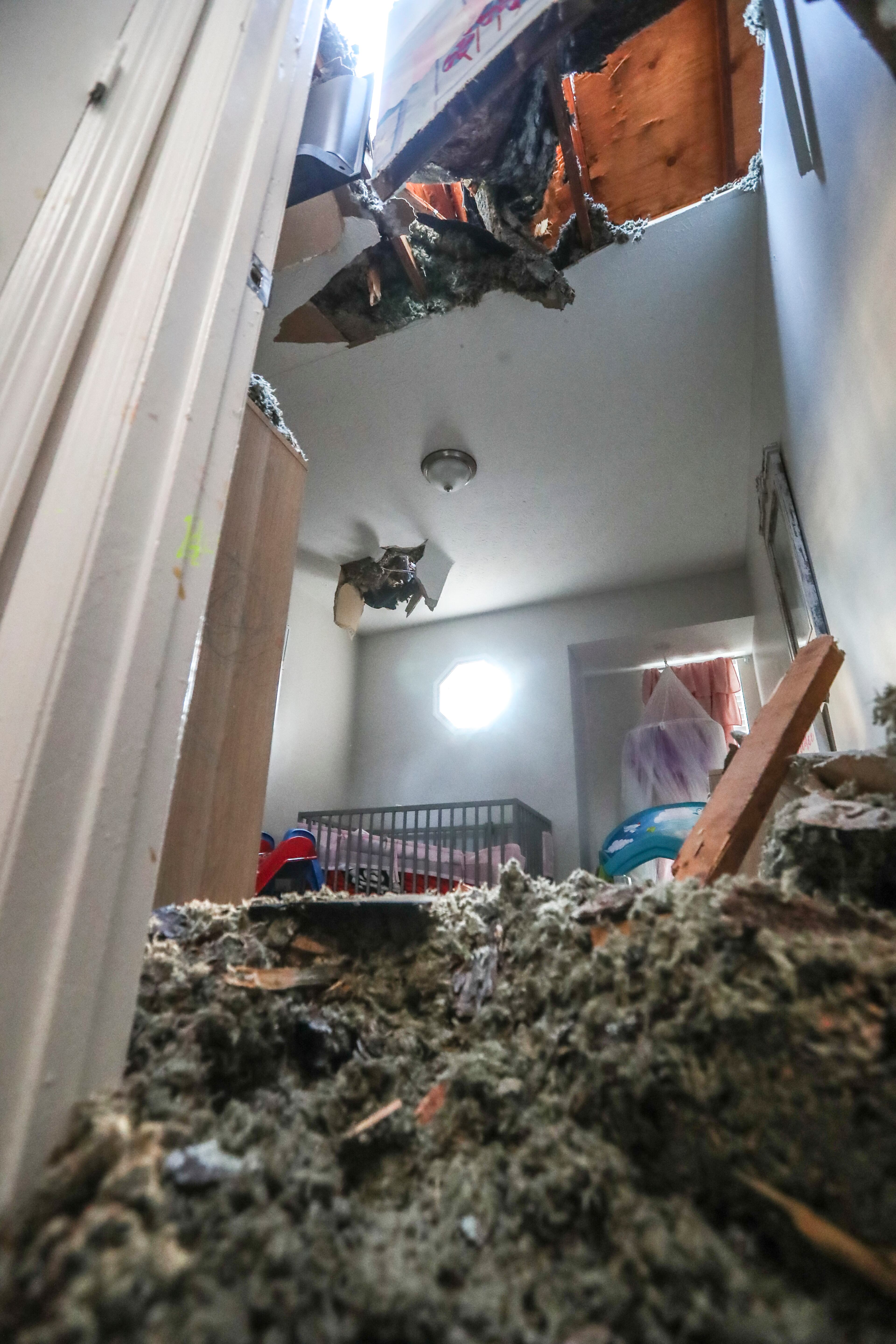 Ashlee Johnson said she stopped pushing on the door to her daughter's room after she realized a hole in the ceiling above her crib was widening. She had to wait for help from DeKalb County fire crews. (John Spink / John.Spink@ajc.com)