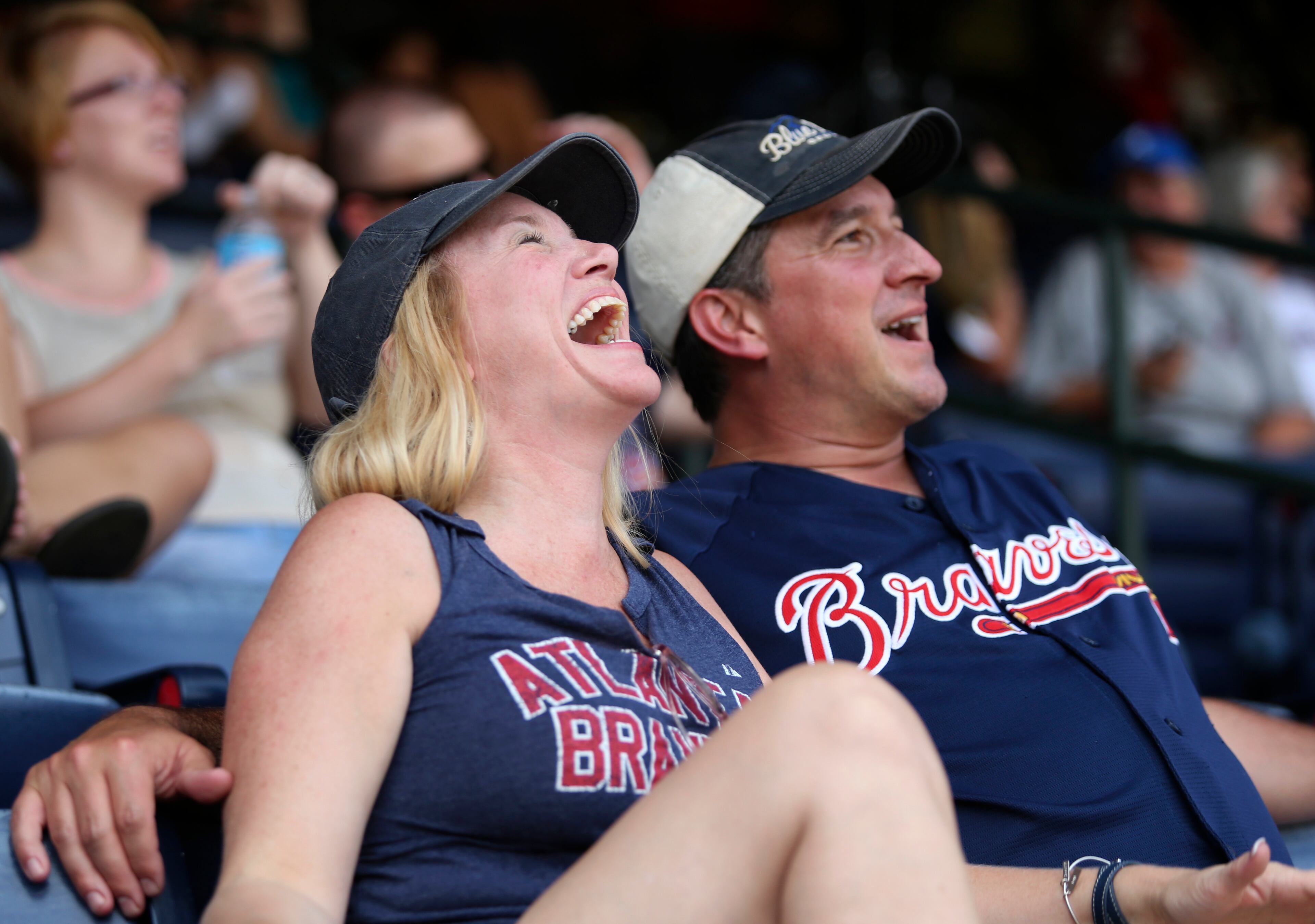 Merry, left, and her husband Mike Quarles, of Woodstock, react to a comment by former Braves manager Bobby Cox as they watched the 2014 National Baseball Hall of Fame induction ceremony before the start of the Braves game against the San Diego Padres at Turner Field Sunday afternoon in Atlanta, Ga., July 27, 2014. Turner Field gates opened early to show the induction ceremony. Fans received a commemorative poster of the three Braves inductees on arrival. JASON GETZ / SPECIAL
