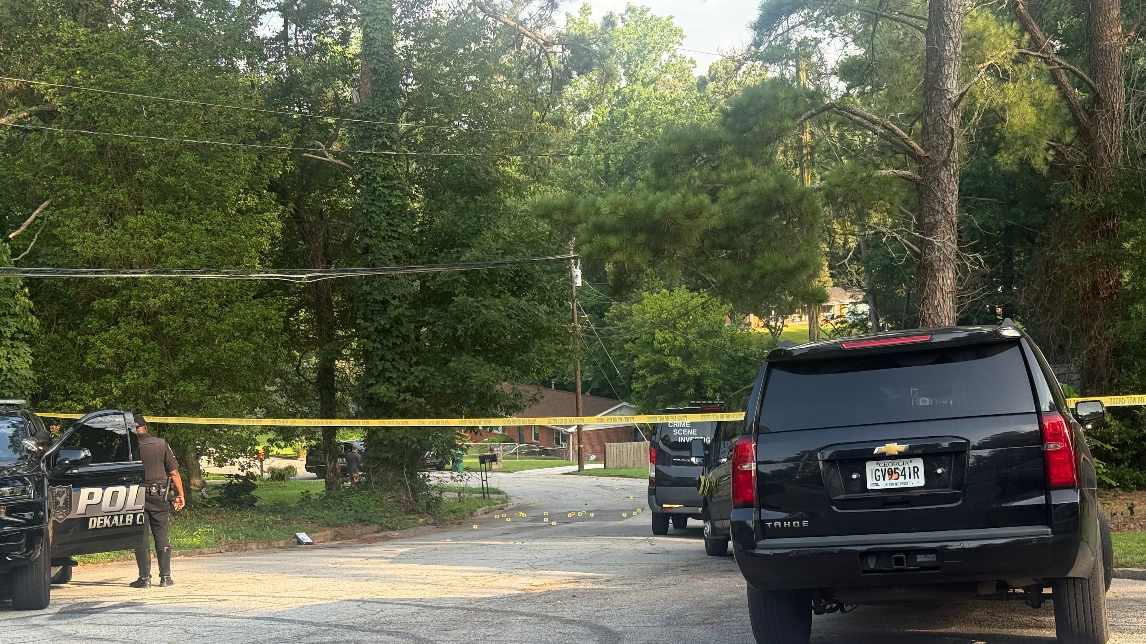 Multiple evidence markers are on a street near the DeKalb County shooting site, which remained blocked for several hours after early Thursday morning gunfire. (Eric Stirgus/AJC)
