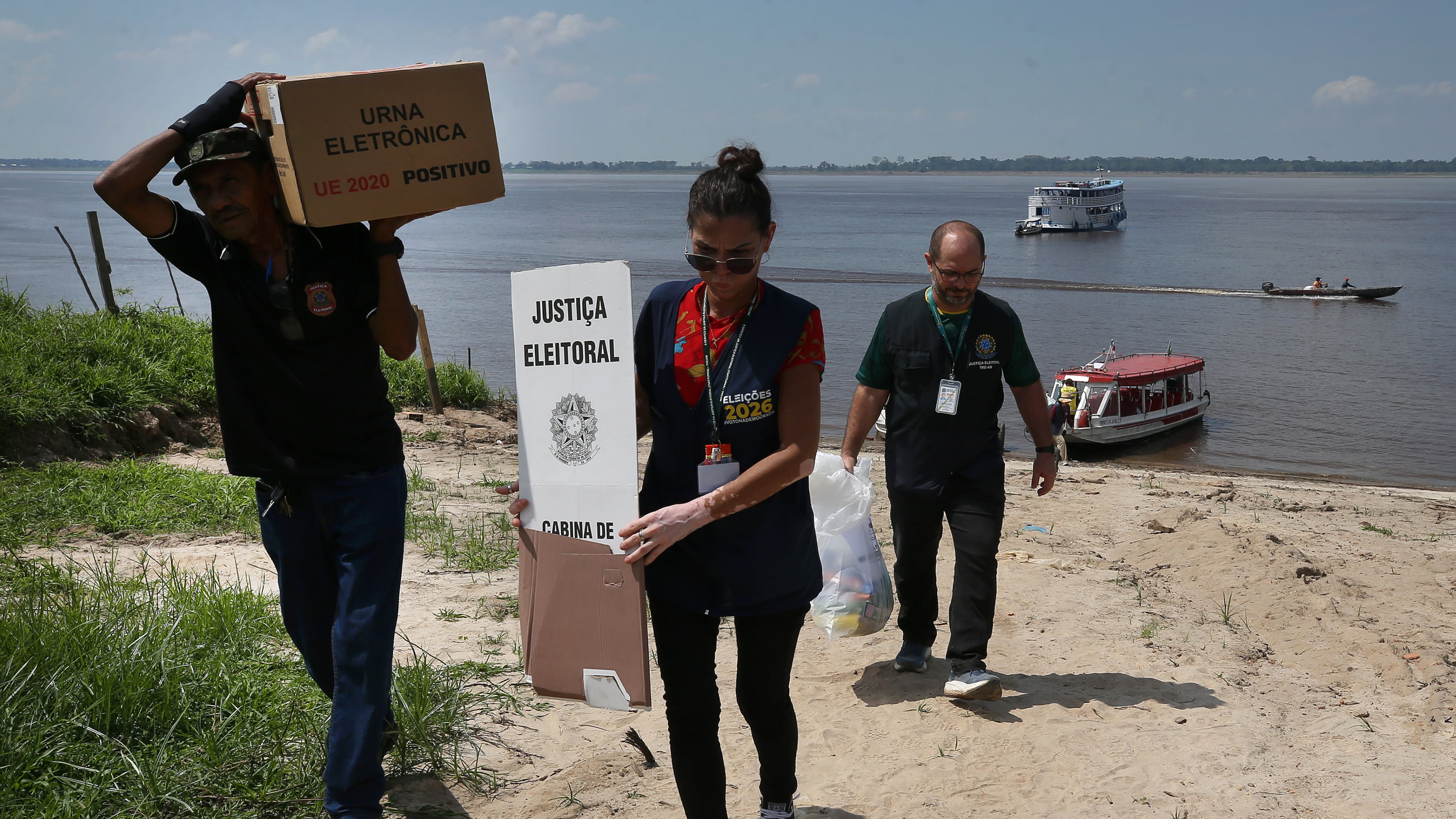 Electoral workers unload electronic voting machines to be taken to a polling station a day ahead of the country's general elections in the rural riverside community of Costa do Jatuarana, Amazonas state, Brazil, Saturday, Oct. 3, 2026. (AP Photo/Edmar Barros)