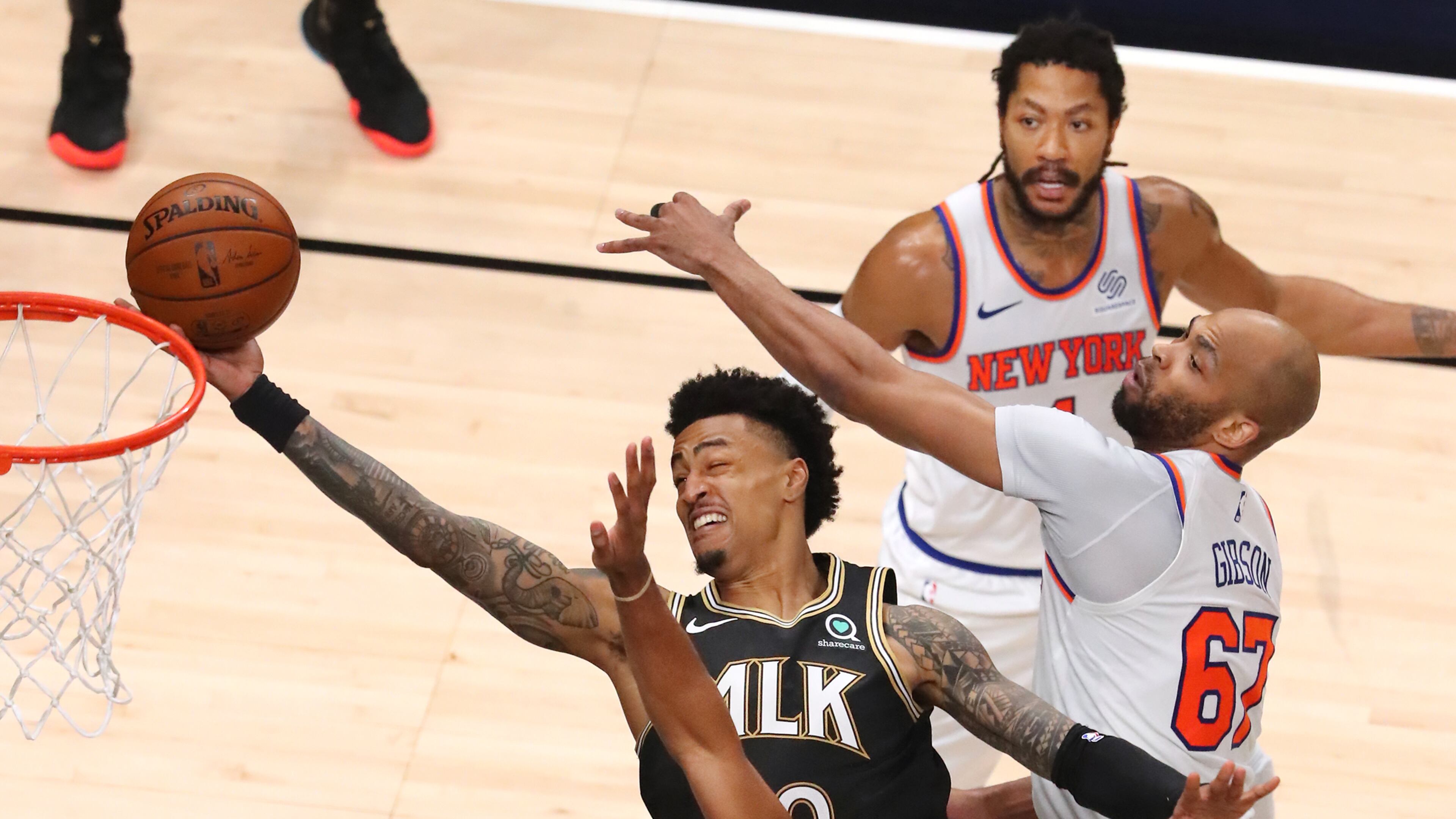 Hawks forward John Collins goes to the basket through a triple team by New York Knicks defenders Alec Burks (clockwise from bottom left), Derrick Rose and Taj Gibson during 113-96 Hawks win of Game 4 of first-round NBA playoff series Sunday, May 30, 2021, at State Farm Arena in Atlanta. (Curtis Compton / Curtis.Compton@ajc.com)