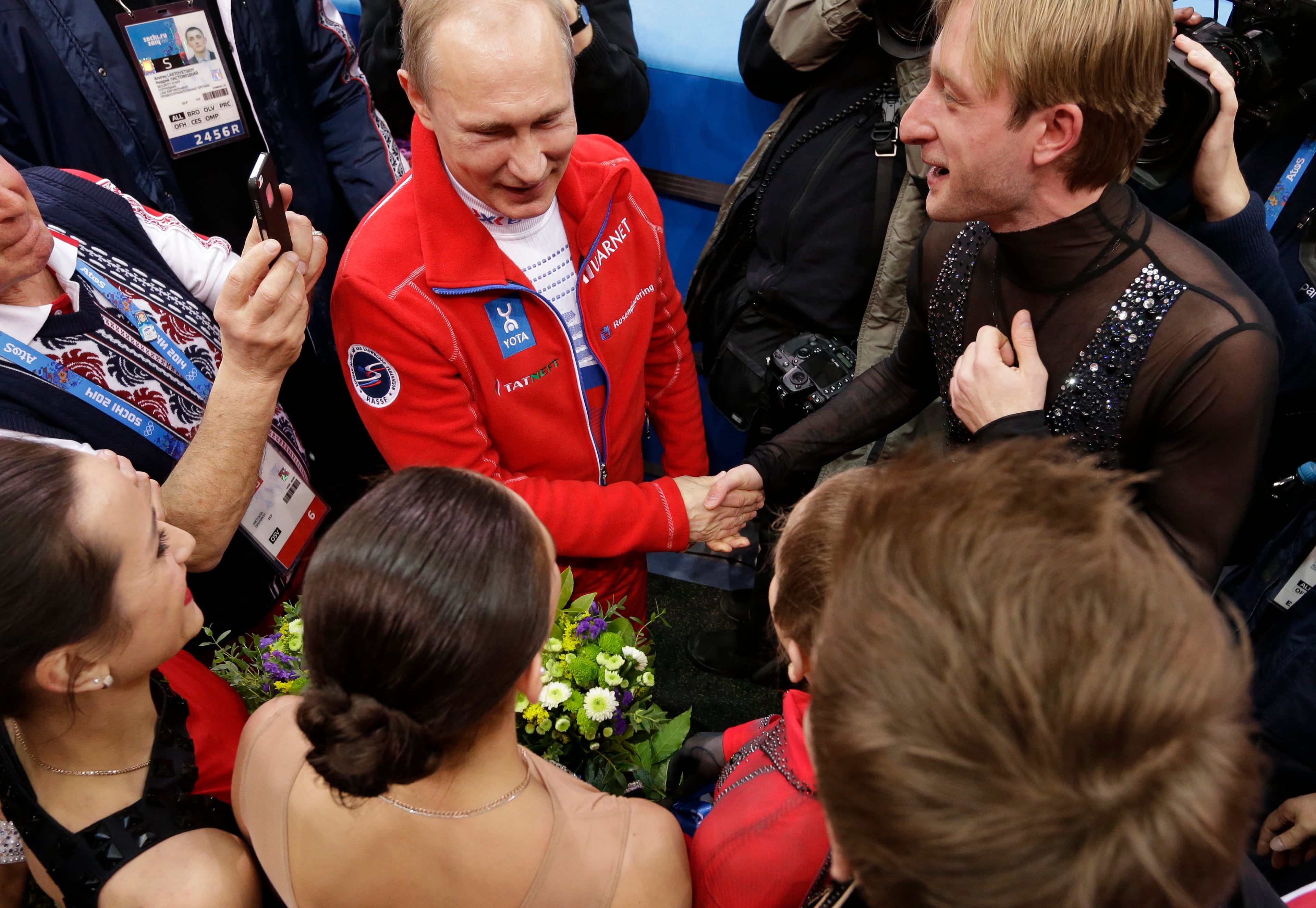 Russian President Vladimir Putin, centre, shakes hands with Evgeni Plushenko of Russia, right, as he congratulates the Russian team for their first place in the team figure skating competition at the Iceberg Skating Palace during the 2014 Winter Olympics, Sunday, Feb. 9, 2014, in Sochi, Russia. (AP Photo/David J. Phillip )