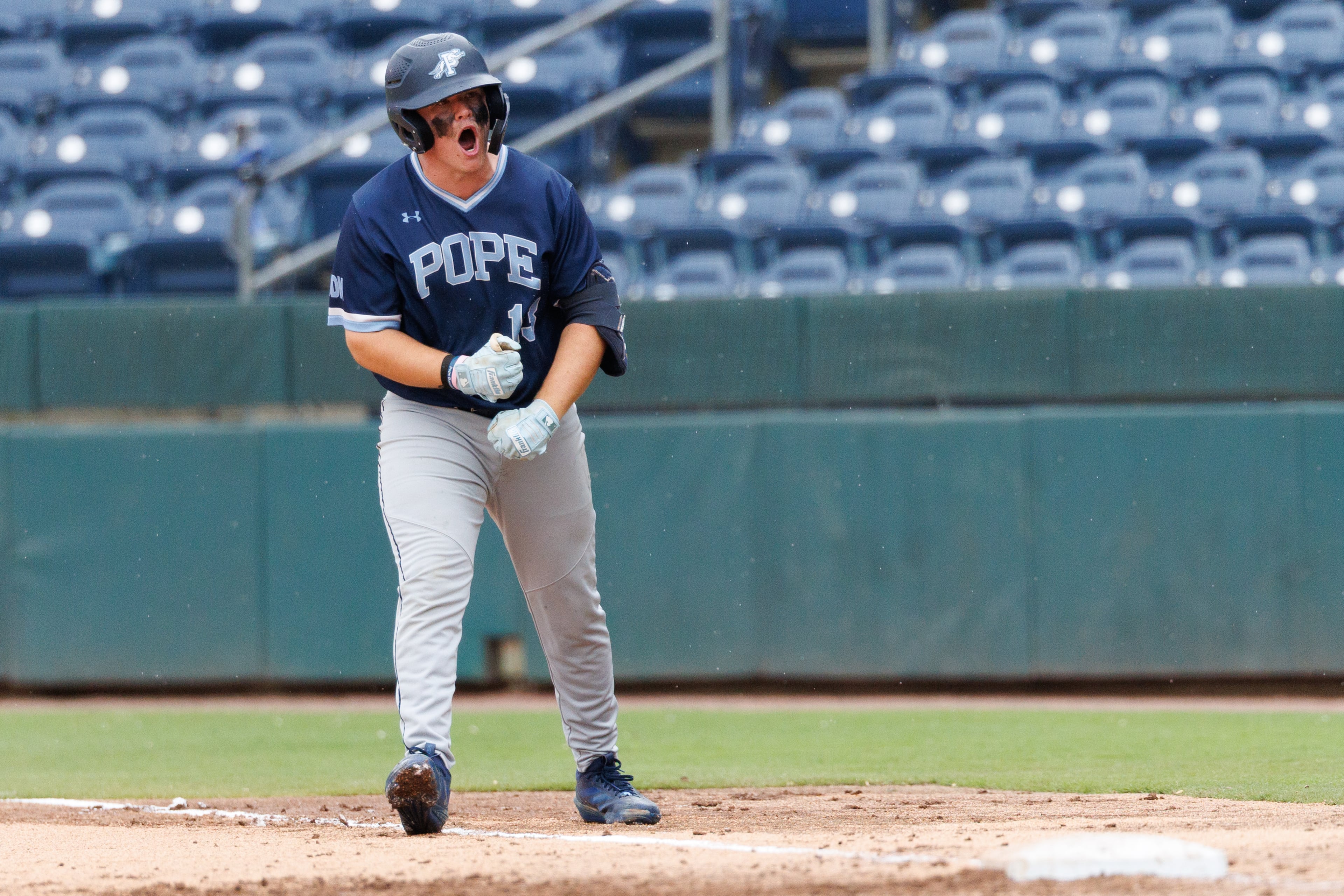 Pope left fielder Ben Hill celebrates at first base during the sixth inning of Game 1 of the GHSA Class 5A baseball state championship series Monday, May 25, 2026, at Gwinnett Field in Lawrenceville. (Estela Muñoz/AJC)