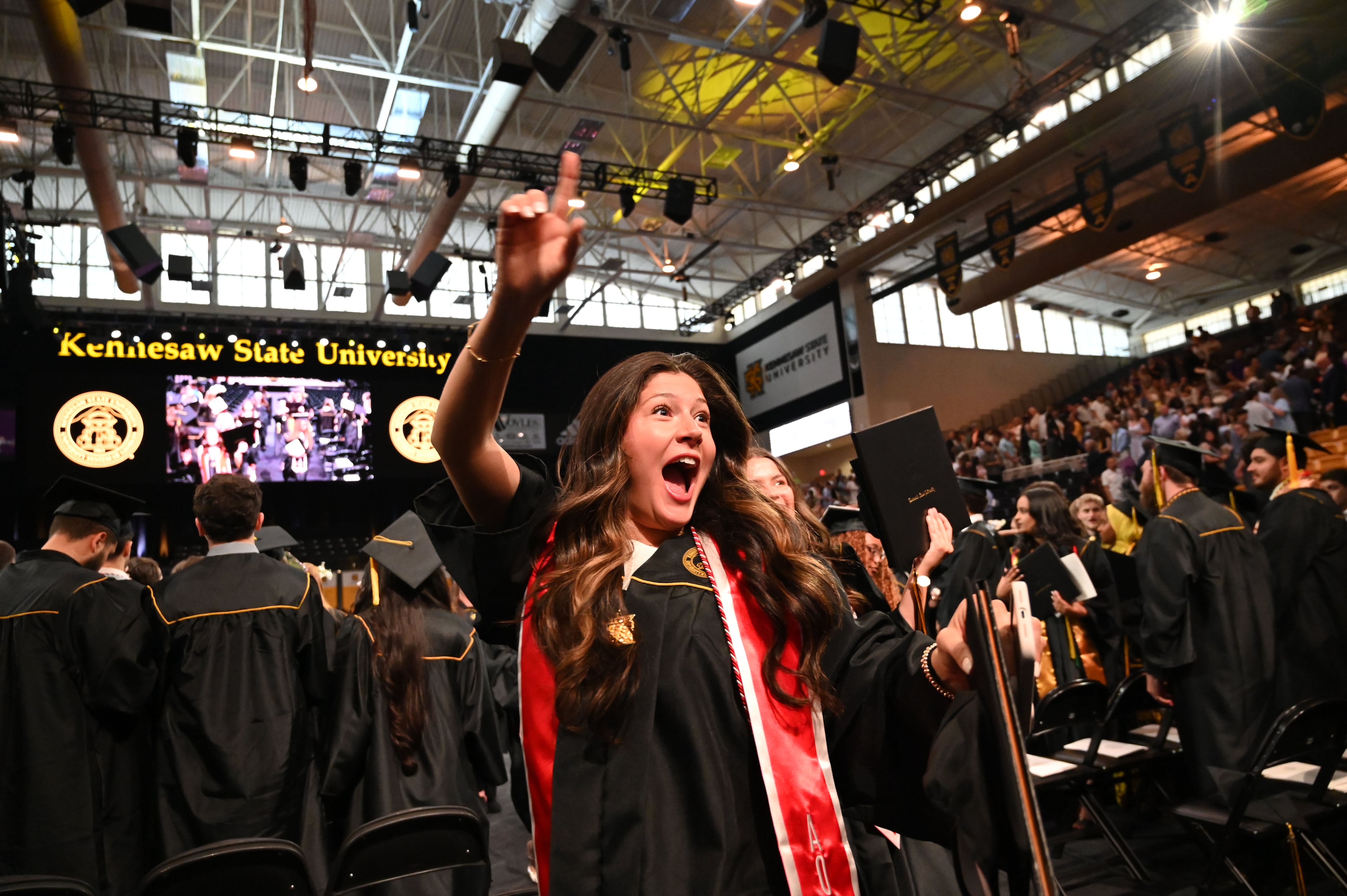 Graduates react as they leave KSU Convocation Center with their diploma in hand. (Hyosub Shin/AJC)
