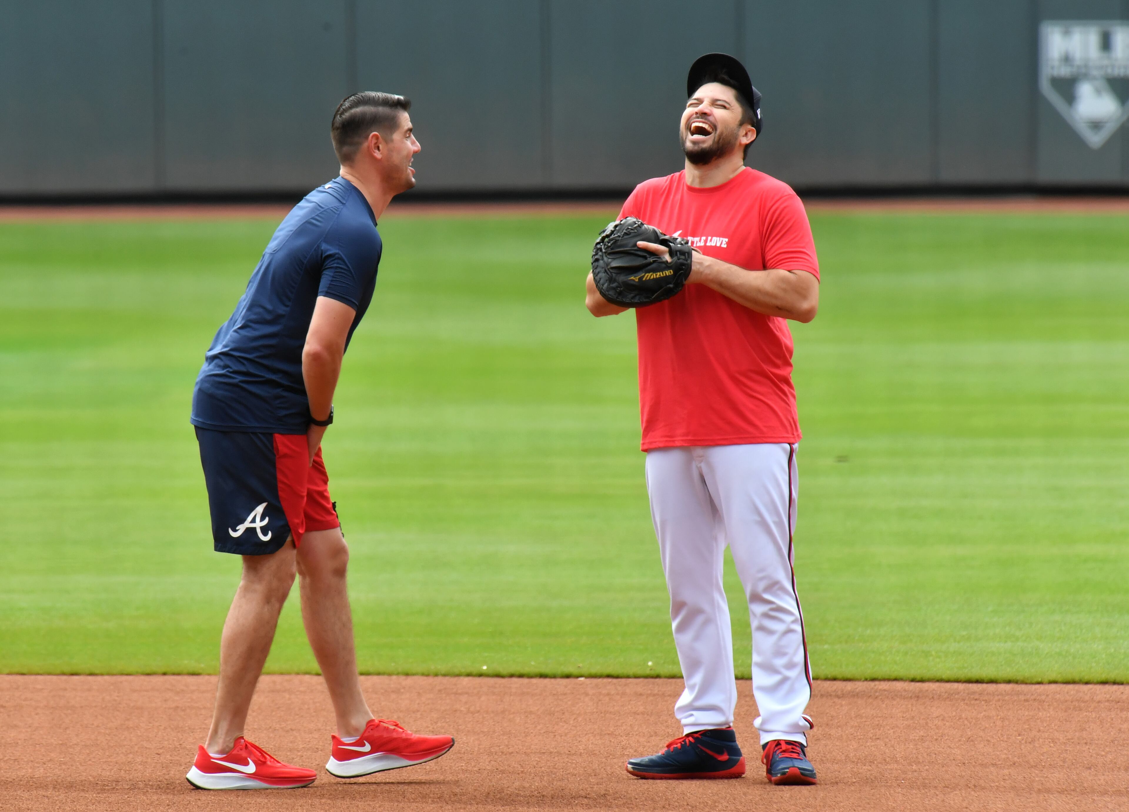 Braves catcher catcher Travis d'Arnaud (right) laughs during a workout. (Hyosub Shin / Hyosub.Shin@ajc.com)