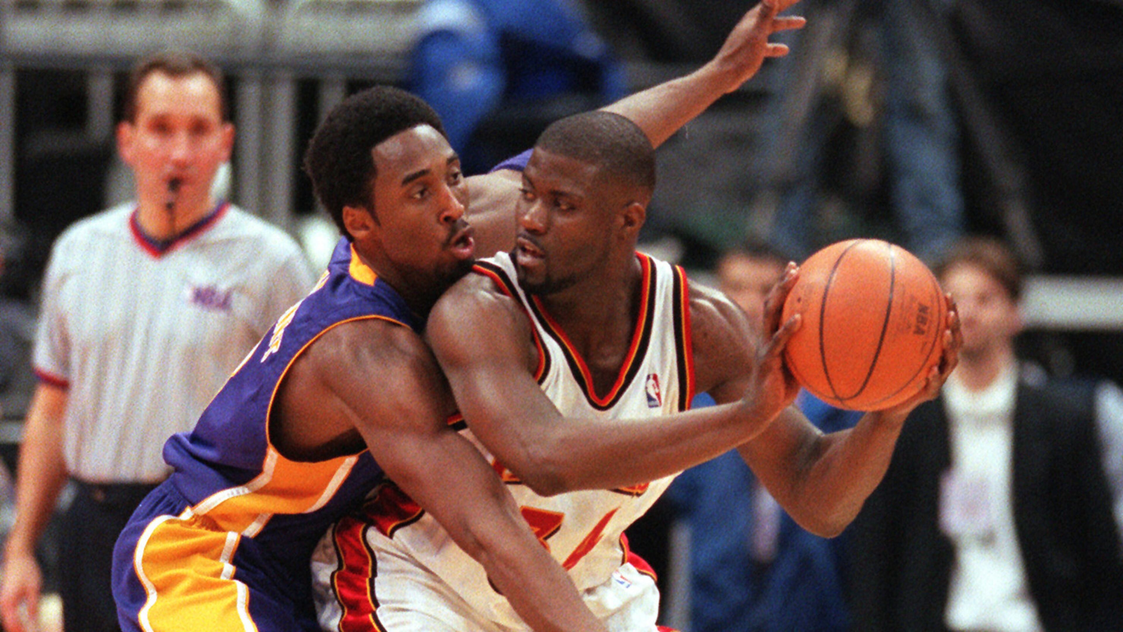 The Lakers' Kobe Bryant closely guards the Hawks' Isaiah Rider in first half Dec. 16, 1999, at Philips arena in Atlanta. Bryant scored 30 points.