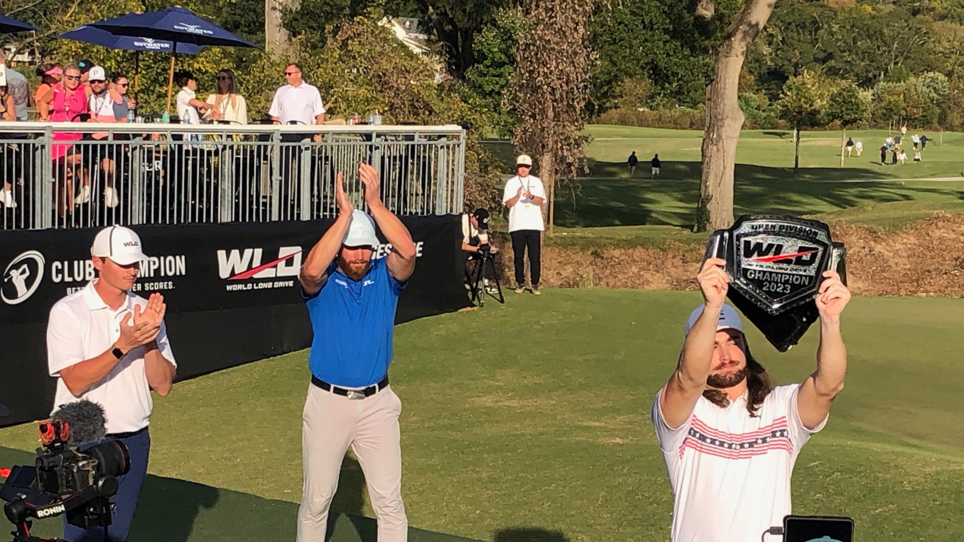 Kyle Berkshire (right) celebrates his third World Long Drive championship after receiving the title belt from 2022 champion Martiin Borgmeier on Oct. 22, 2023 at Bobby Jones Golf Course in Atlanta.