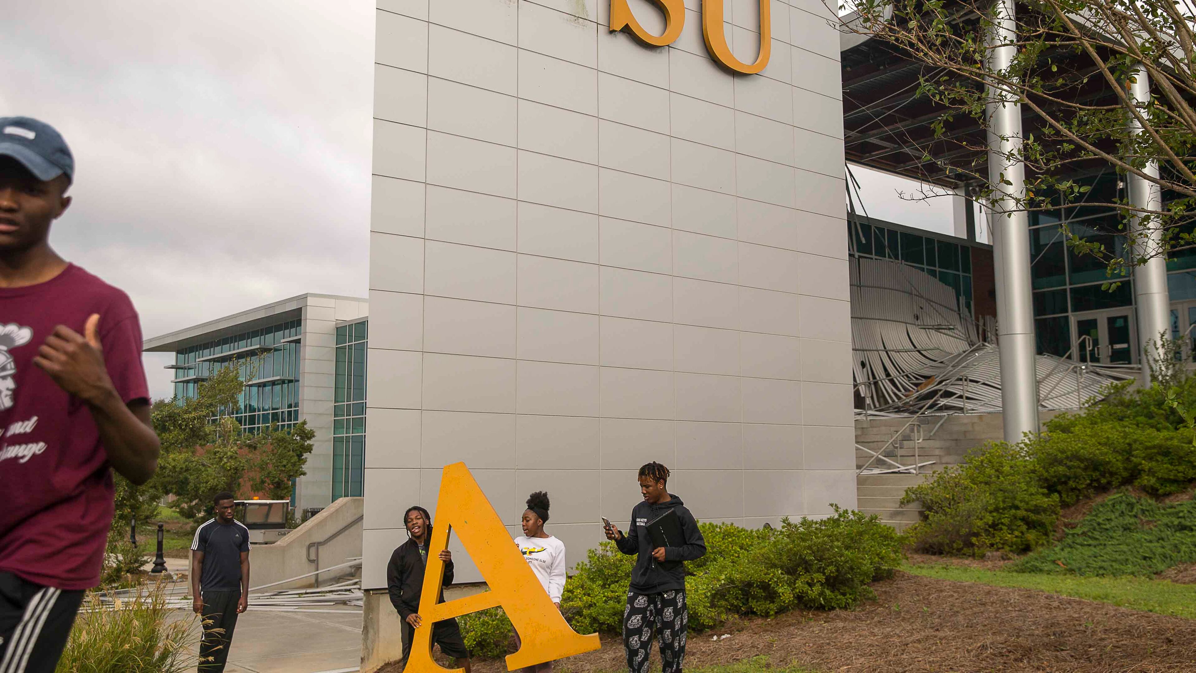 10/11/2018 -- Albany, Georgia -- Students at Albany State University take photographs with a decorative letter that fell off the student center building on the main campus in Albany, Thursday, October 11, 2018. Parts of the campus were destroyed due to Hurricane Michael. (ALYSSA POINTER/ALYSSA.POINTER@AJC.COM)