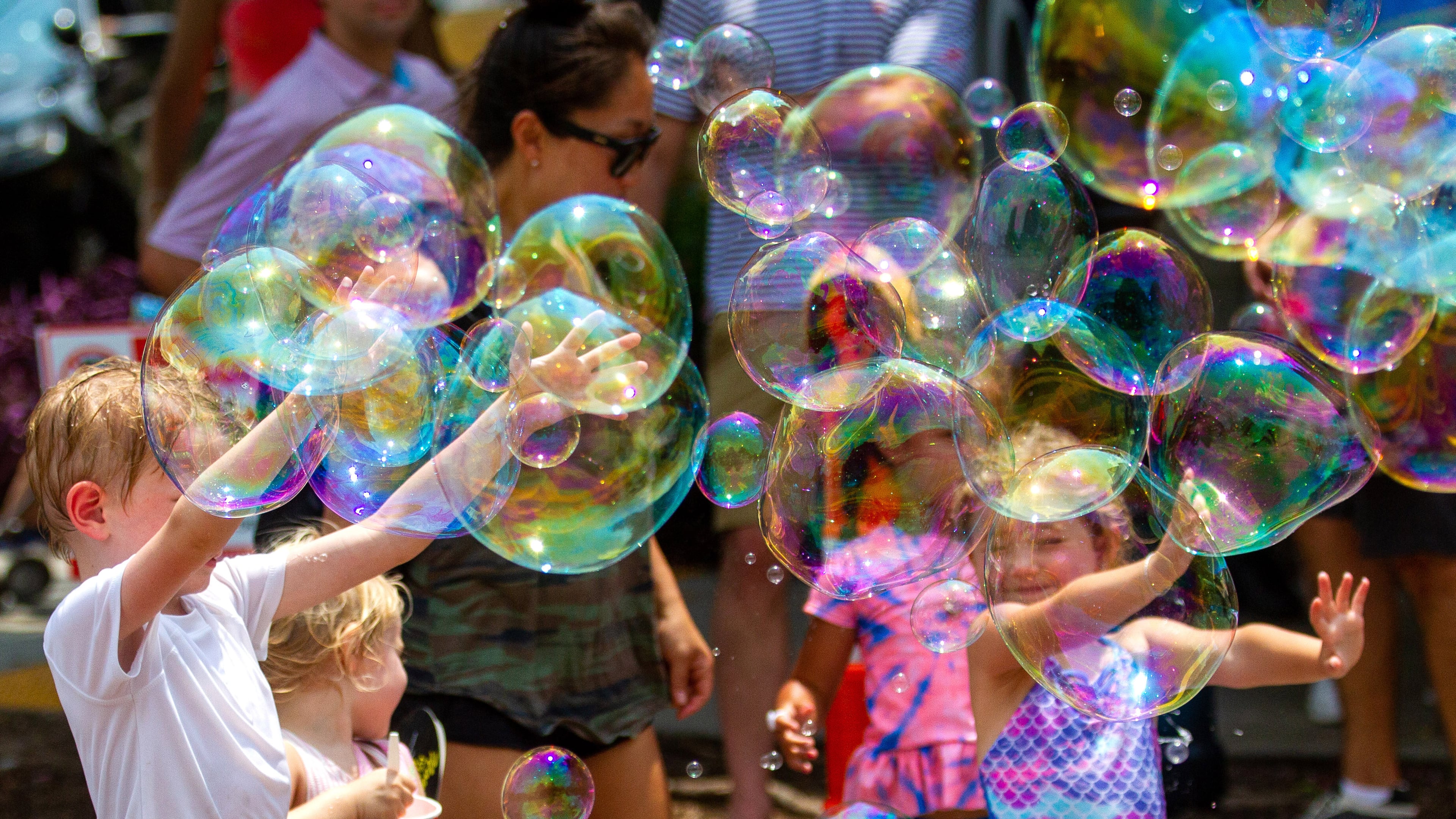 Kids pop large bubbles created by Deborah Mosher during the Brookhaven Cherry Blossom Festival Saturday, July 31, 2021STEVE SCHAEFER FOR THE ATLANTA JOURNAL-CONSTITUTION