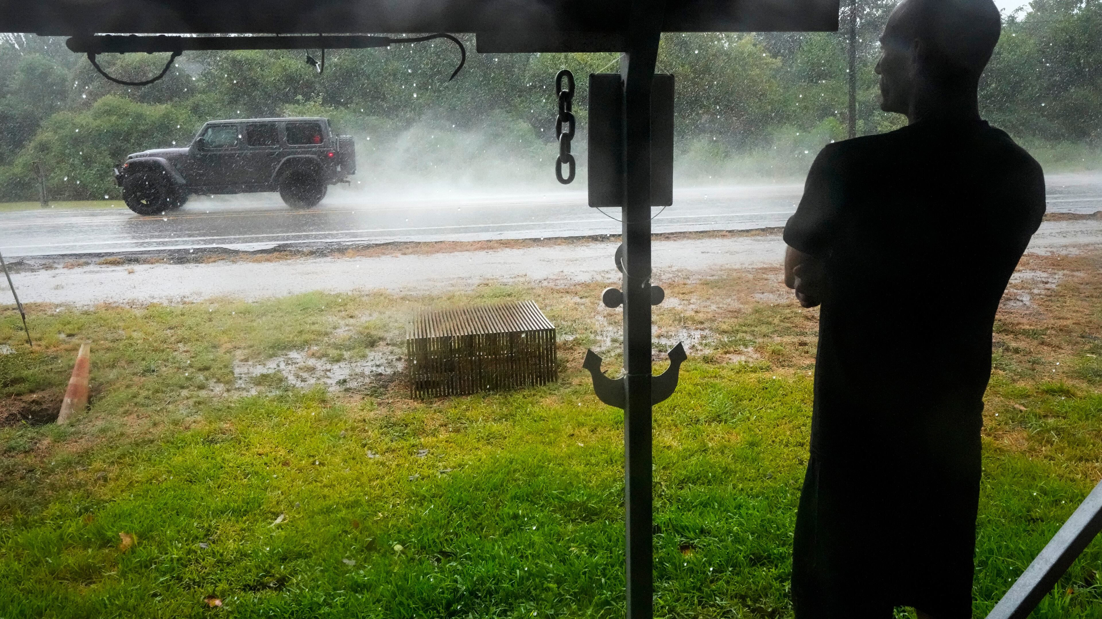 Michael Espinoza stands under the awning of his shop, T&M Bait Shop, watching rain from Tropical Storm Edouard come down in High Island, Texas, on Tuesday, Sept. 1, 2026. (Brett Coomer/Houston Chronicle via AP)