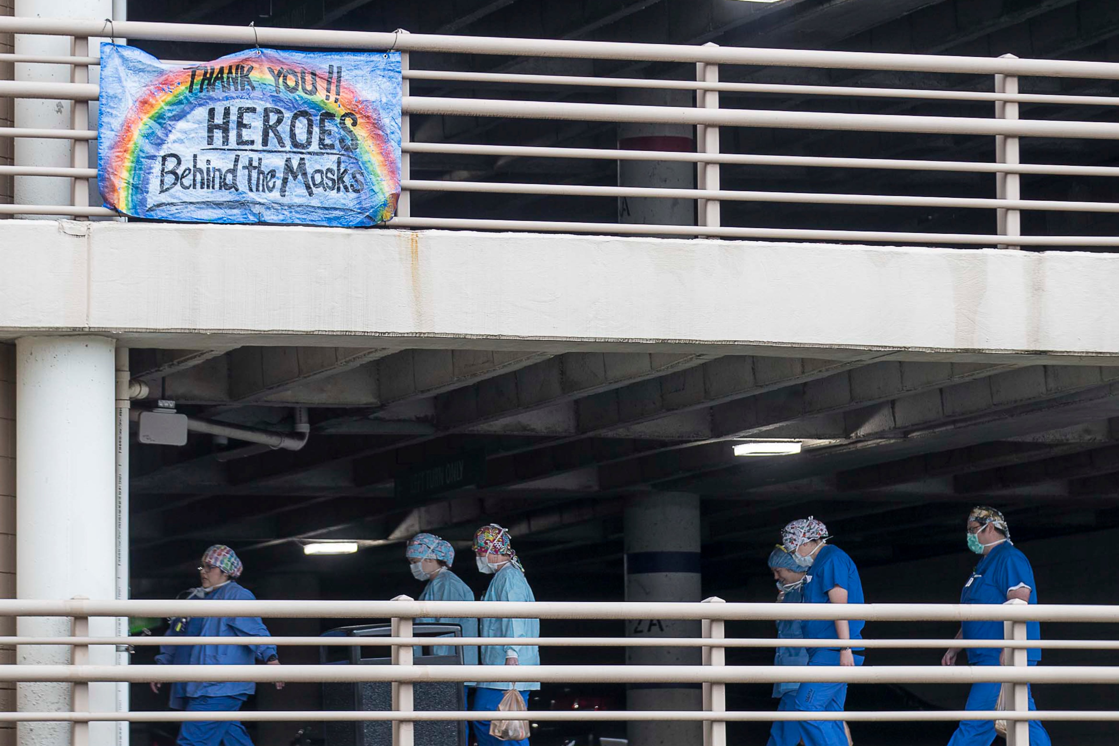 An encouraging banner is displayed on a parking garage as medical professionals walk toward the entrance of Floyd Medical Center in Rome, Georgia, on Thursday, April 23, 2020. (ALYSSA POINTER / Alyssa.Pointer@AJC.com)