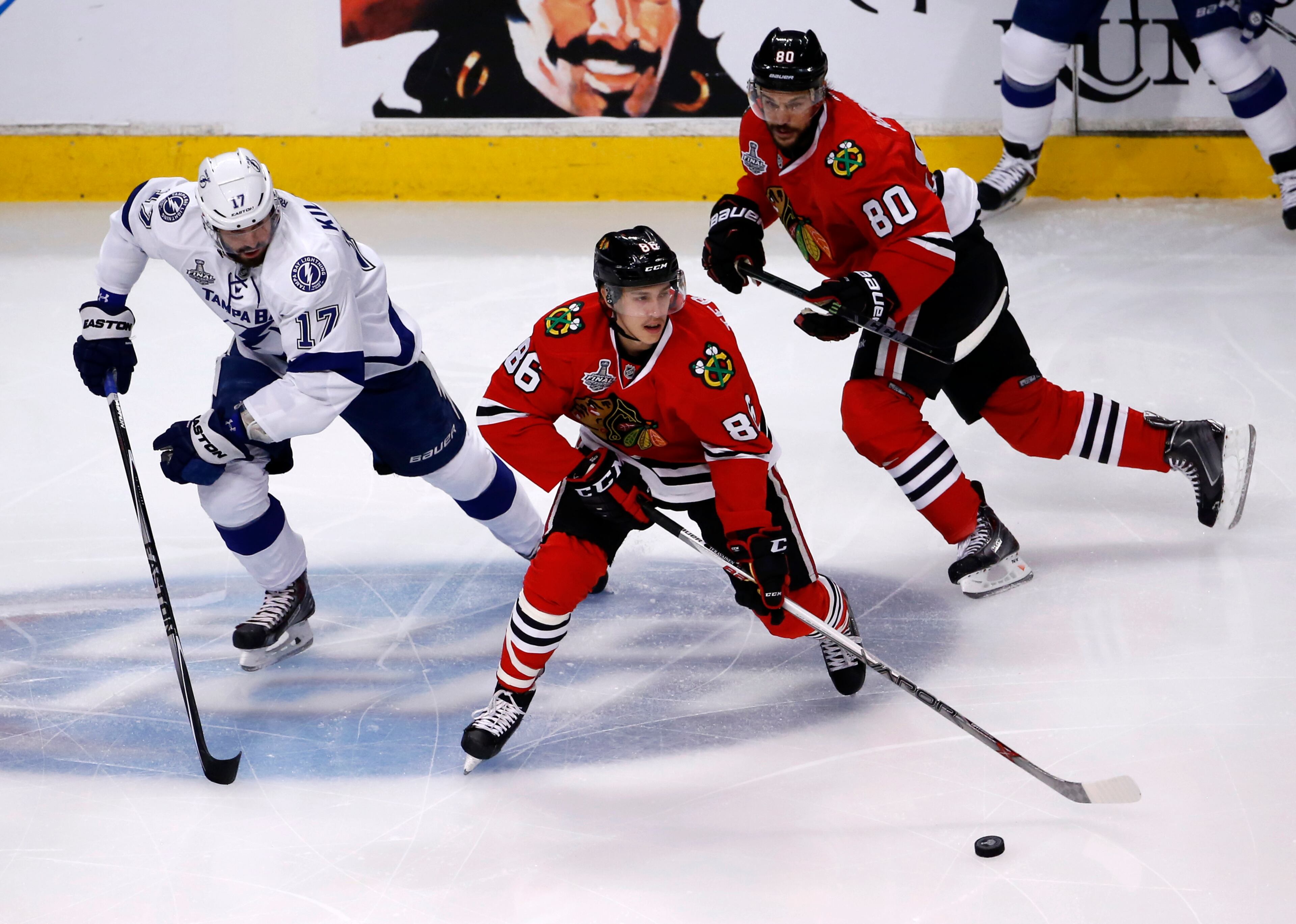 Chicago Blackhawks' Teuvo Teravainen, of Finland, handles the puck as teammate Antoine Vermette, right, and Tampa Bay Lightning's Alex Killorn, left, watch during the first period in Game 3 of the NHL hockey Stanley Cup Final on Monday, June 8, 2015, in Chicago. (AP Photo/Charles Rex Arbogast)