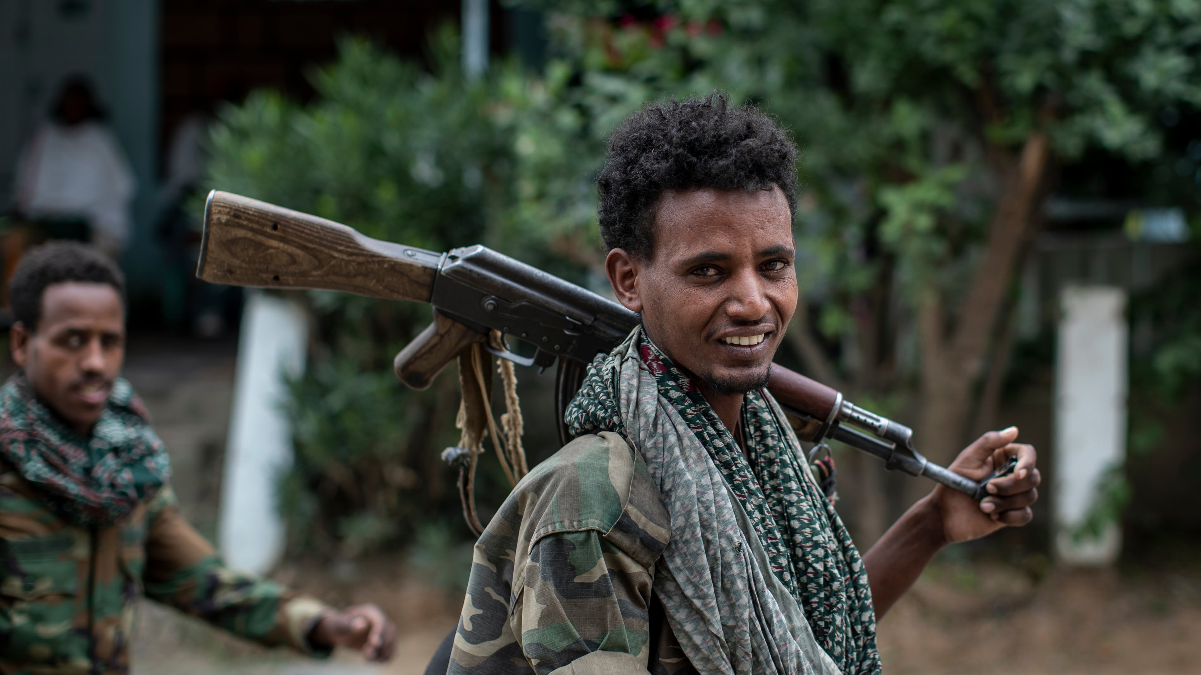 FILE - Fighters loyal to the Tigray People's Liberation Front (TPLF) walk along a street in the town of Hawzen, then controlled by the group, in the Tigray region of northern Ethiopia, May 7, 2021. (AP Photo/Ben Curtis, File)