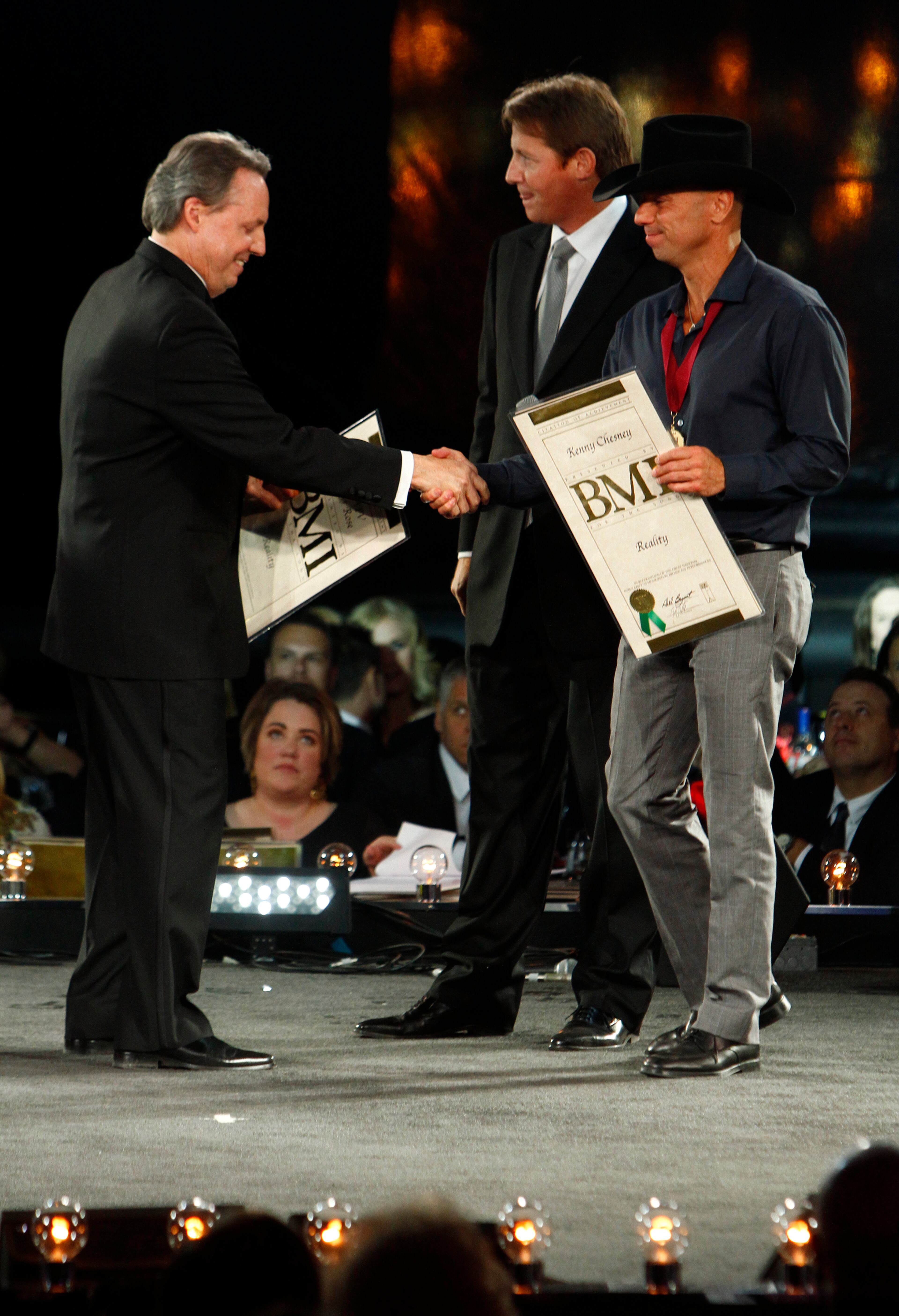 Kenny Chesney, right, is congratulated by Jody Williams at the 60th Annual BMI Country Awards on Tuesday Oct. 30, 2012, in Nashville, Tenn. Clay Bradley is behind.