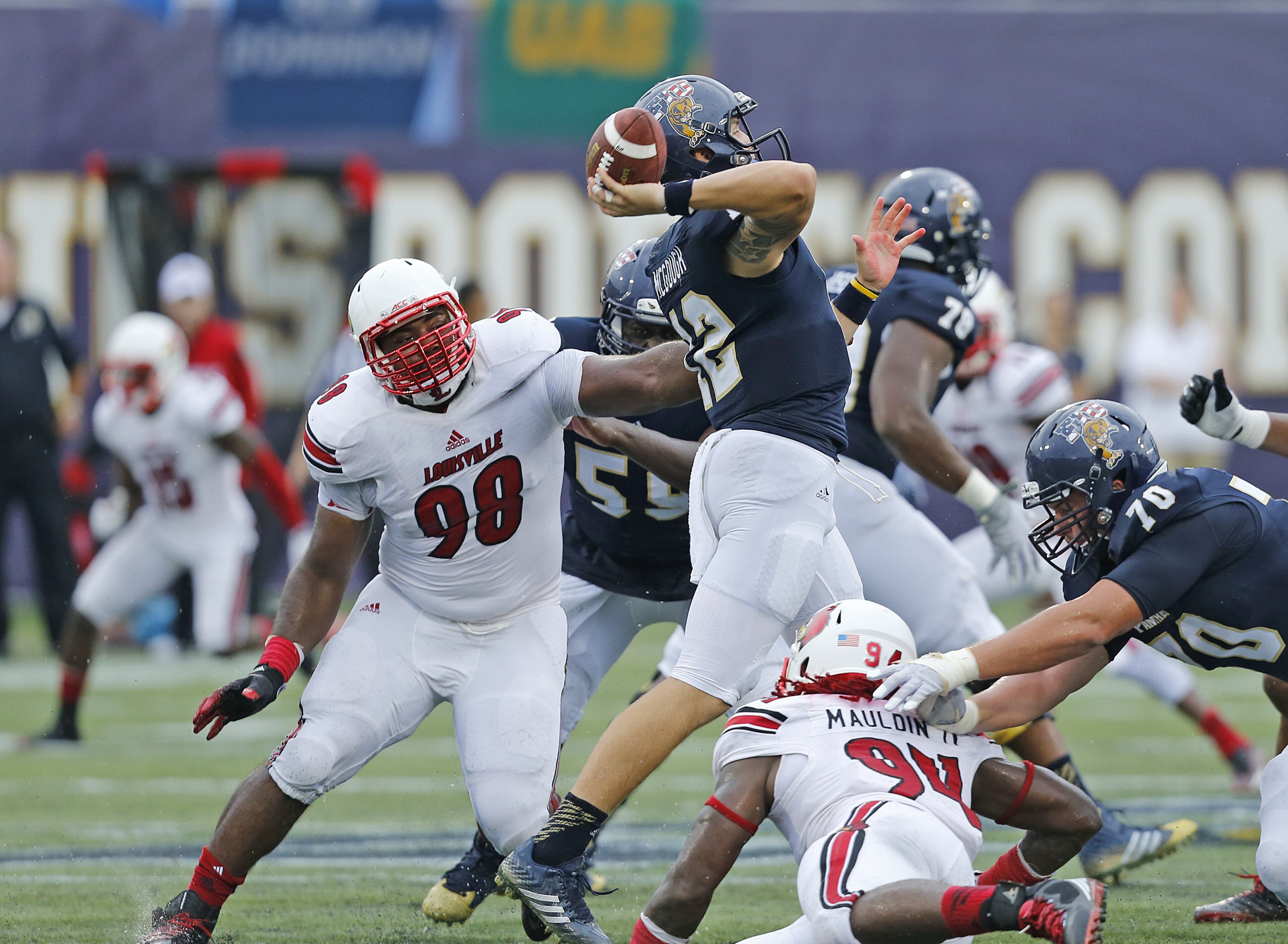 Sheldon Rankins (98) of Louisville hits Alex McGough of Florida International as he releases the ball causing an interception on September 20, 2014 at FIU Stadium in Miami, Florida. (Photo by Joel Auerbach/Getty Images)