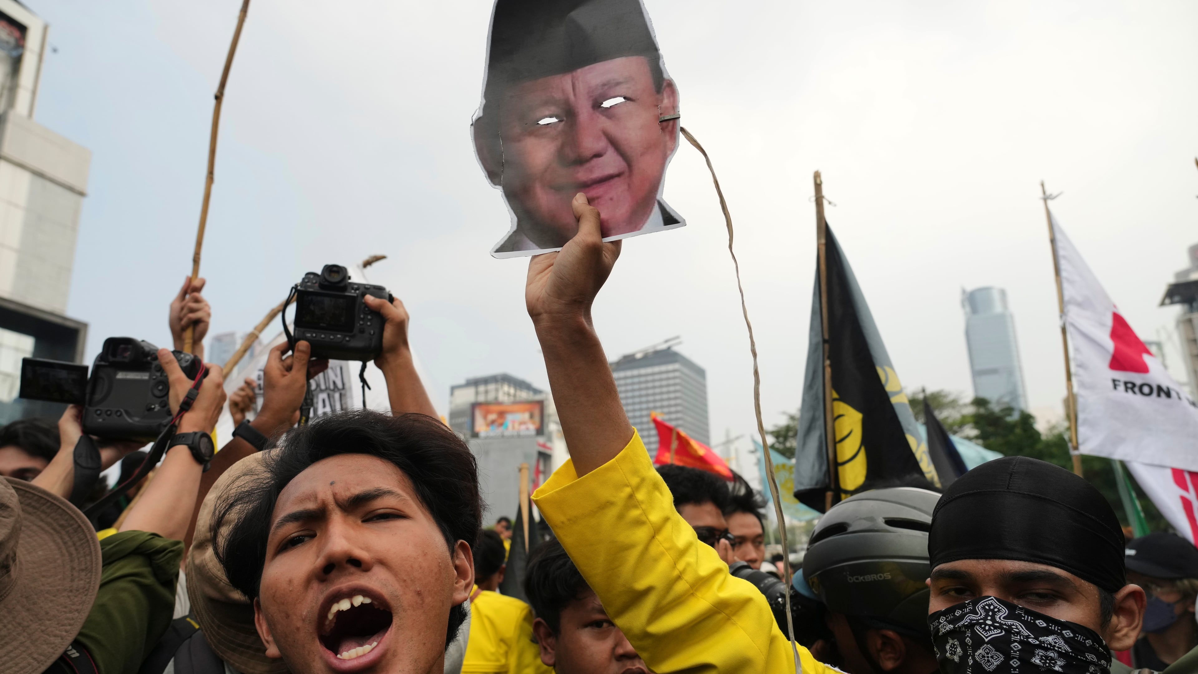 A student protester holds up a mask of Indonesian President Prabowo Subianto during a rally against a fuel price hike, government inefficient spendings, and military involvement in civilian affairs in Jakarta, Indonesia, Friday, June 12, 2026. (AP Photo/Tatan Syuflana)