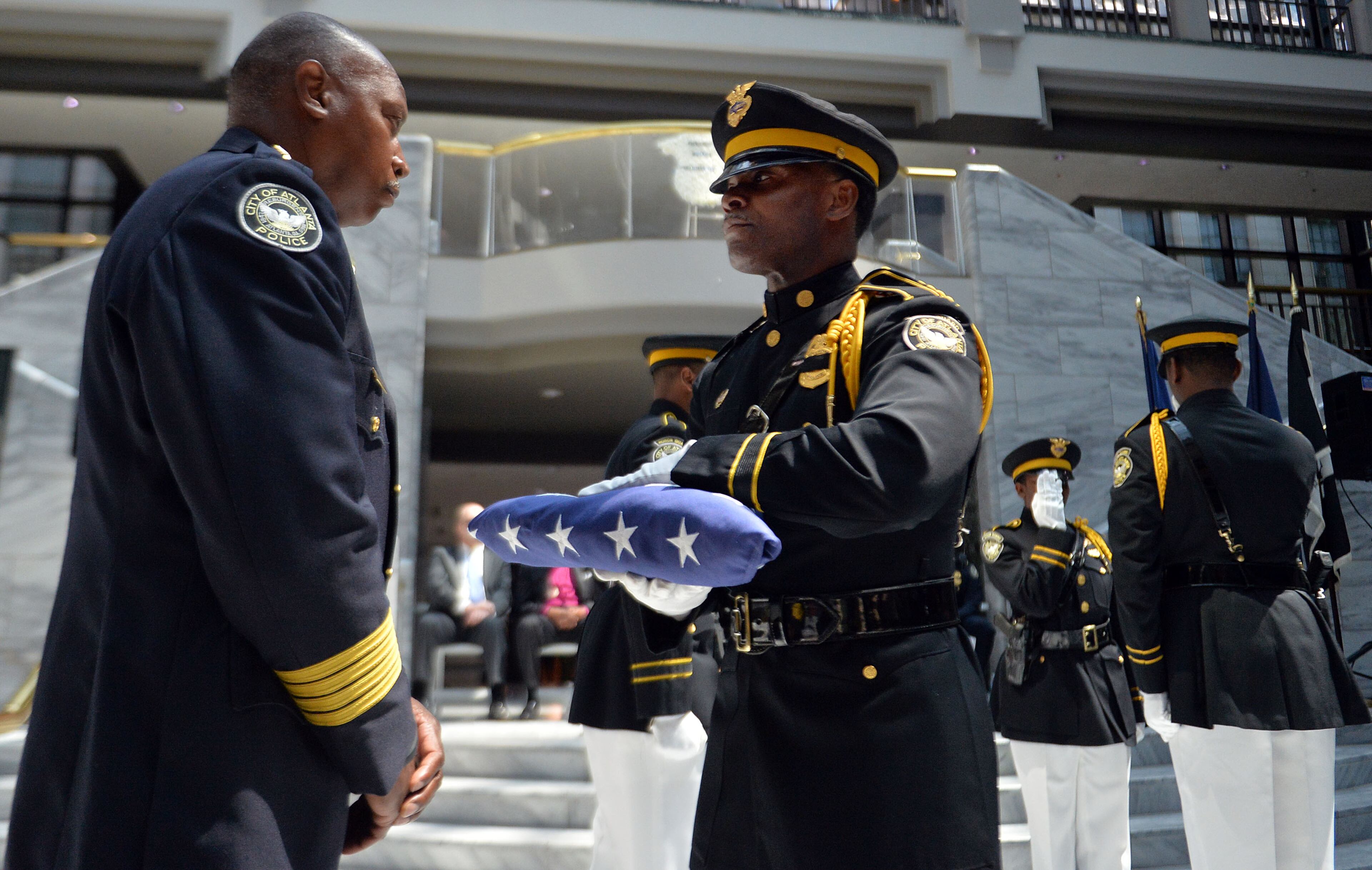 Senior Police Officer Keech Boyd presents the flag to APD Chief George Turner during the service. The Atlanta Police Department recognized 82 fallen officers during the 24th Annual Police Memorial Service at the Atlanta City Hall atrium, Tuesday, May 5, 2015. The Right Rev. Robert C. Wright of the Episcopal Diocese of Atlanta was the keynote speaker. Additional speakers included Atlanta Police Chief George N. Turner, Michael Geisler, Chief Operating Officer, City Council President Ceasar C. Mitchell and Council member C.T. Martin, Public Safety Chair. KENT D. JOHNSON /KDJOHNSON@AJC.COM
