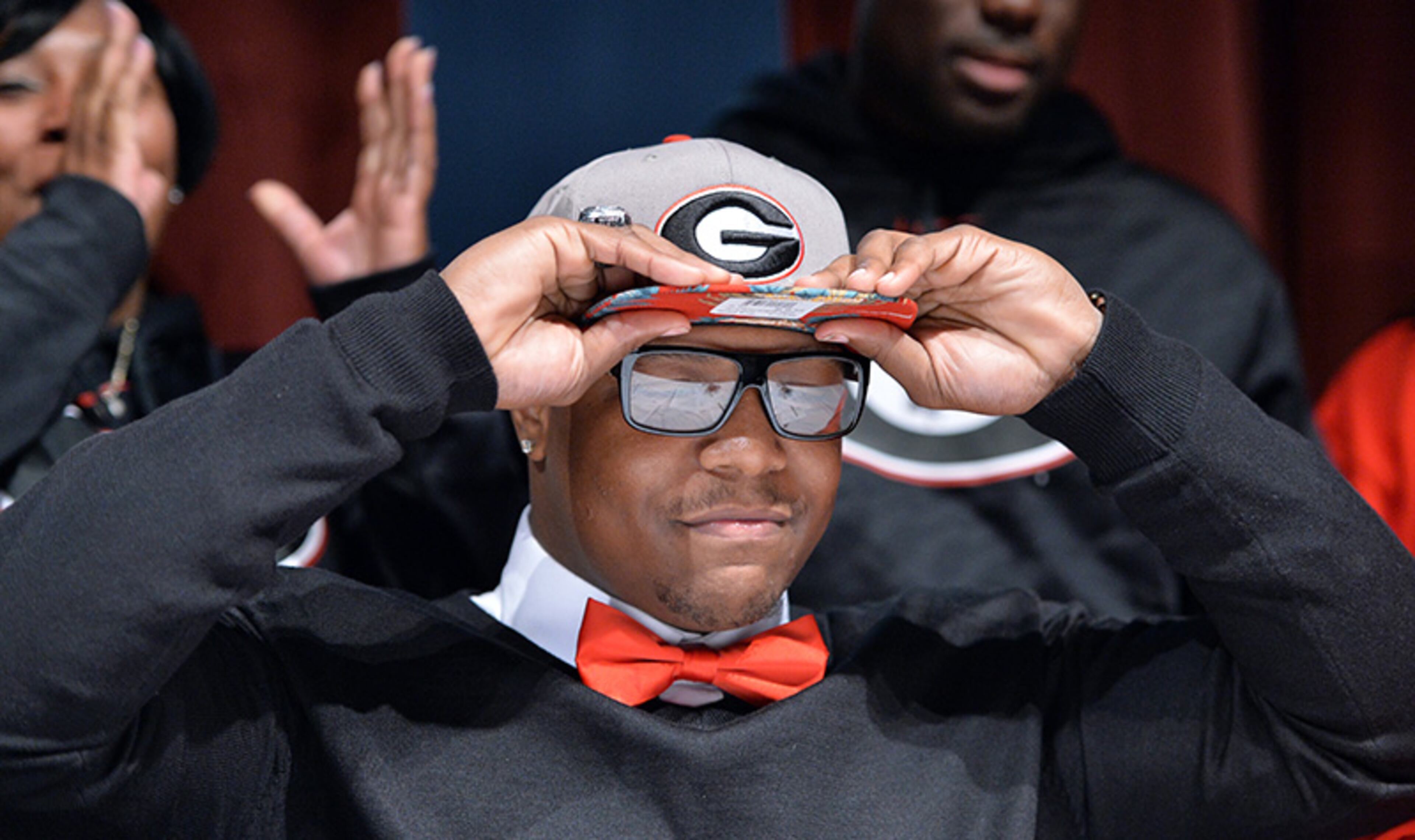 Detric Bing-Dukes cements his choice of Georgia as he puts on his hat during signing day festivities at Tucker High School Wednesday.
