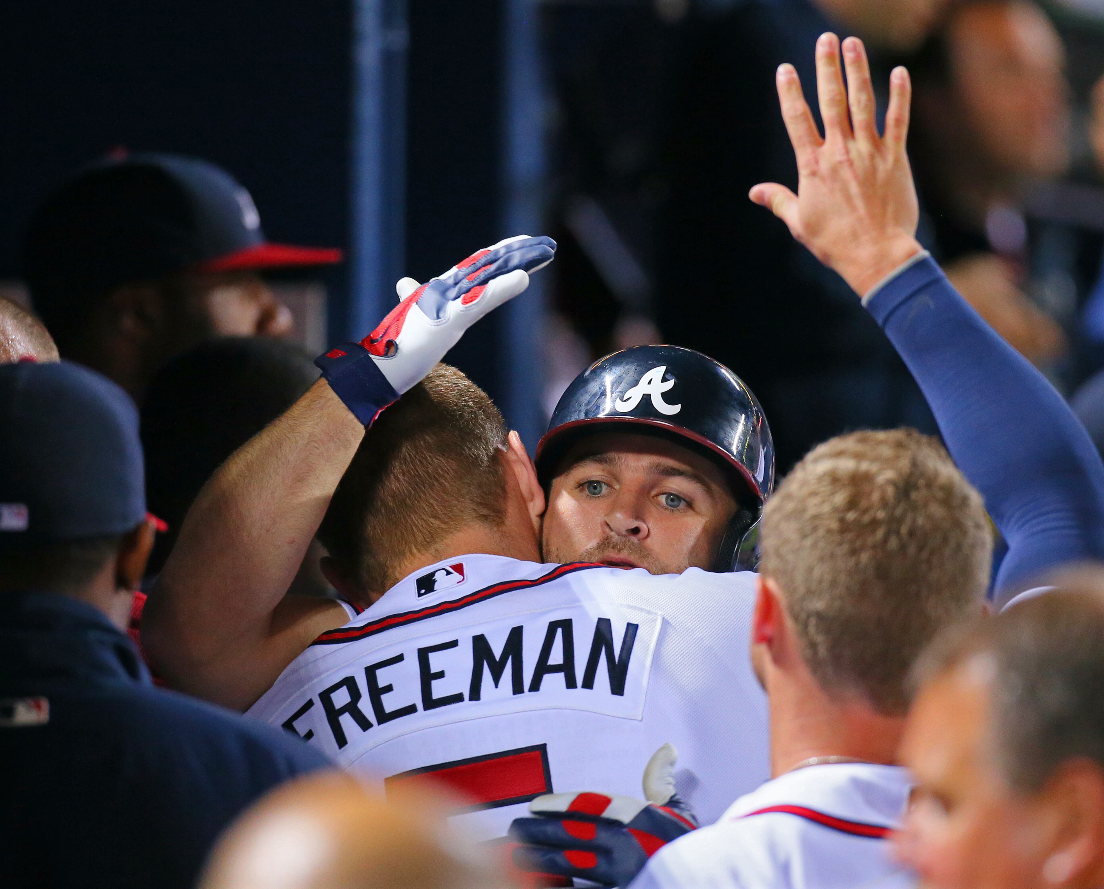 Braves Freddie Freeman greets Uggla in the dugout after Uggla's solo shot.