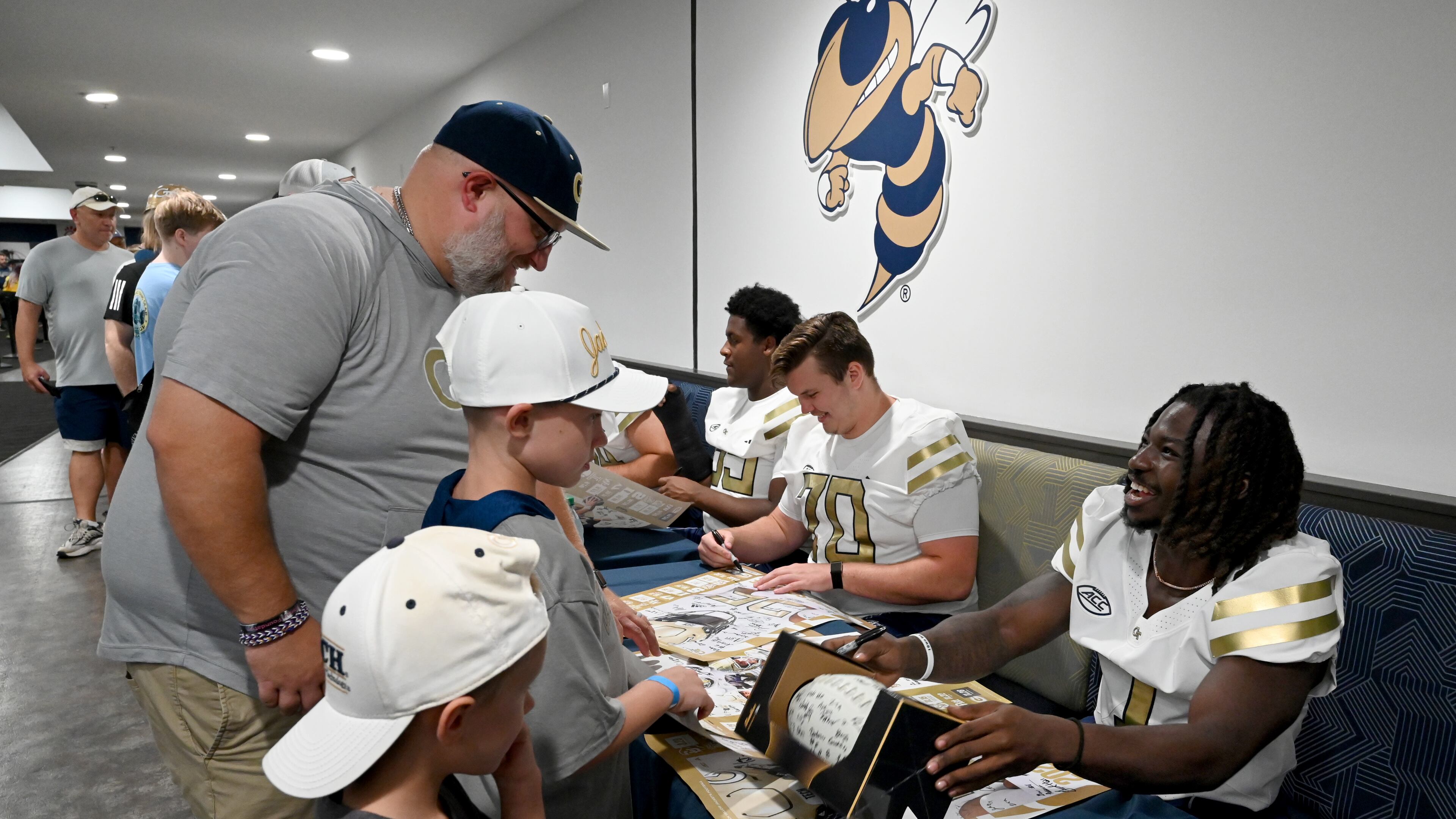 Tech running back Jamal Haynes (right) and other players sign autographs for event attendees during the annual “First Saturday on The Flats” at Bobby Dodd Stadium on Saturday, Aug. 2, 2025, in Atlanta. The running back was one of three Yellow Jackets chosen for the Top 300 list for the 2026 Senior Bowl. (Hyosub Shin/AJC)