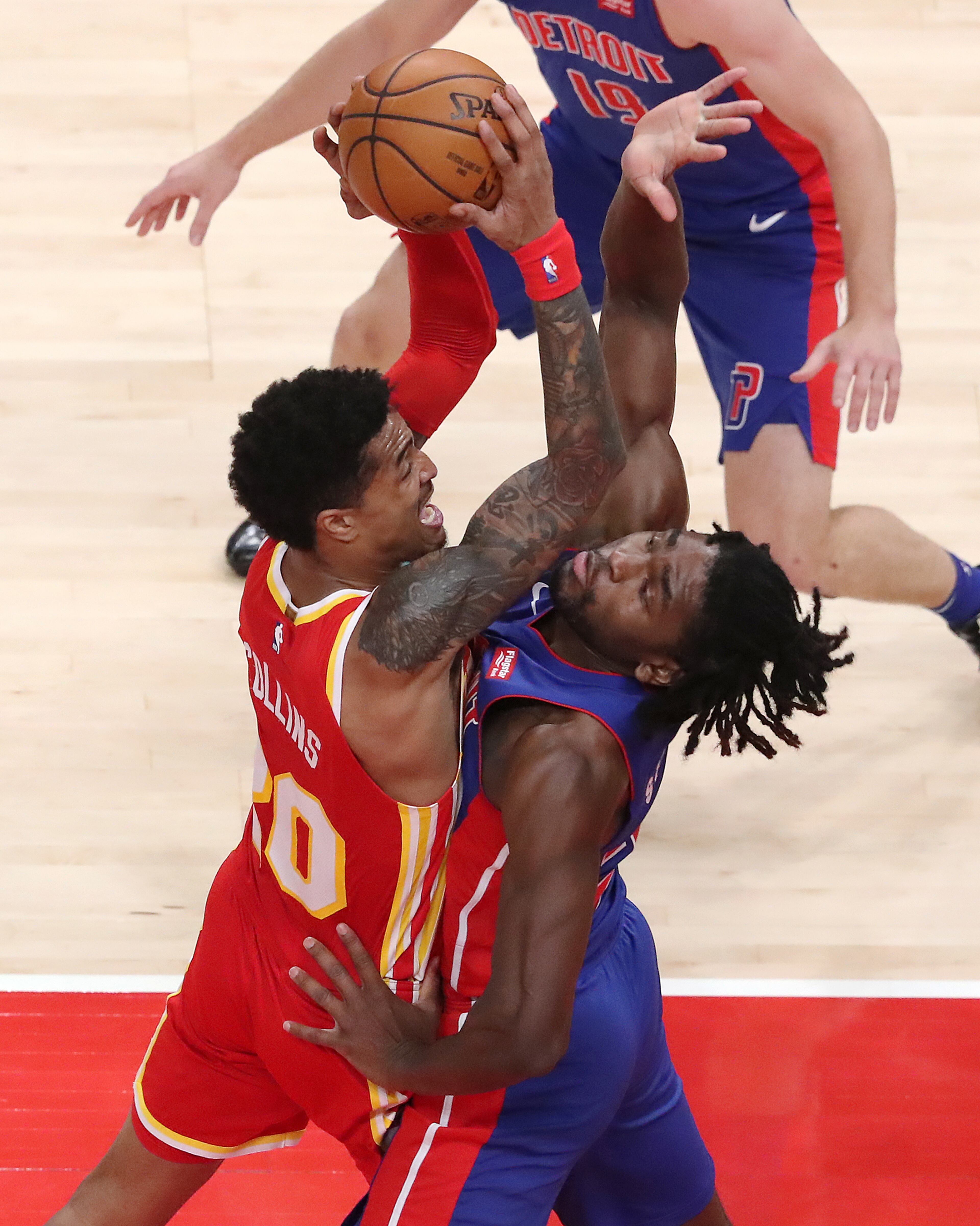 Hawks John Collins goes to the basket for two against Detroit Pistons defender Isaiah Stewart in a NBA basketball game on Monday, Dec. 28, 2020, in Atlanta. “Curtis Compton / Curtis.Compton@ajc.com”