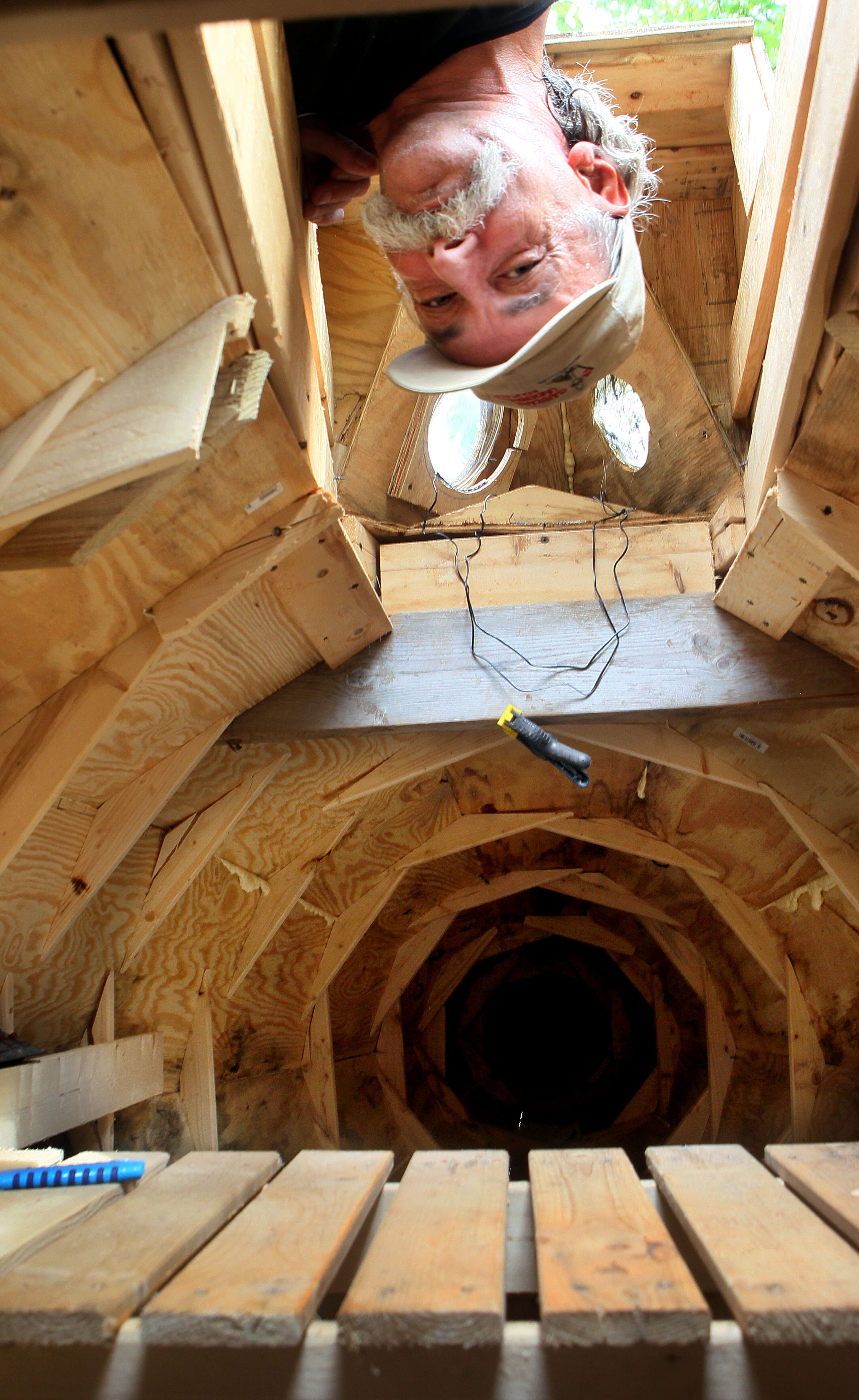 Danny McWilliams sticks his head inside the 36 foot version of the Nautilus he is building at his Ellijay home. The Nautilus is a fantastical machine, piloted by the fanatical Capt. Nemo, in Jules Verne's "20,000 Leagues Under the Sea." When he was a kid, McWilliams saw the 1954 film of the same name, a Disney flick starring Kirk Douglas. He had eyes only for the submarine, depicted as a long, finned contraption, the world's largest mechanical fish. To build the vessel, he has made innumerable trips to the local Home Depot, loading his Dodge Neon with all the lumber it can handle at one time.