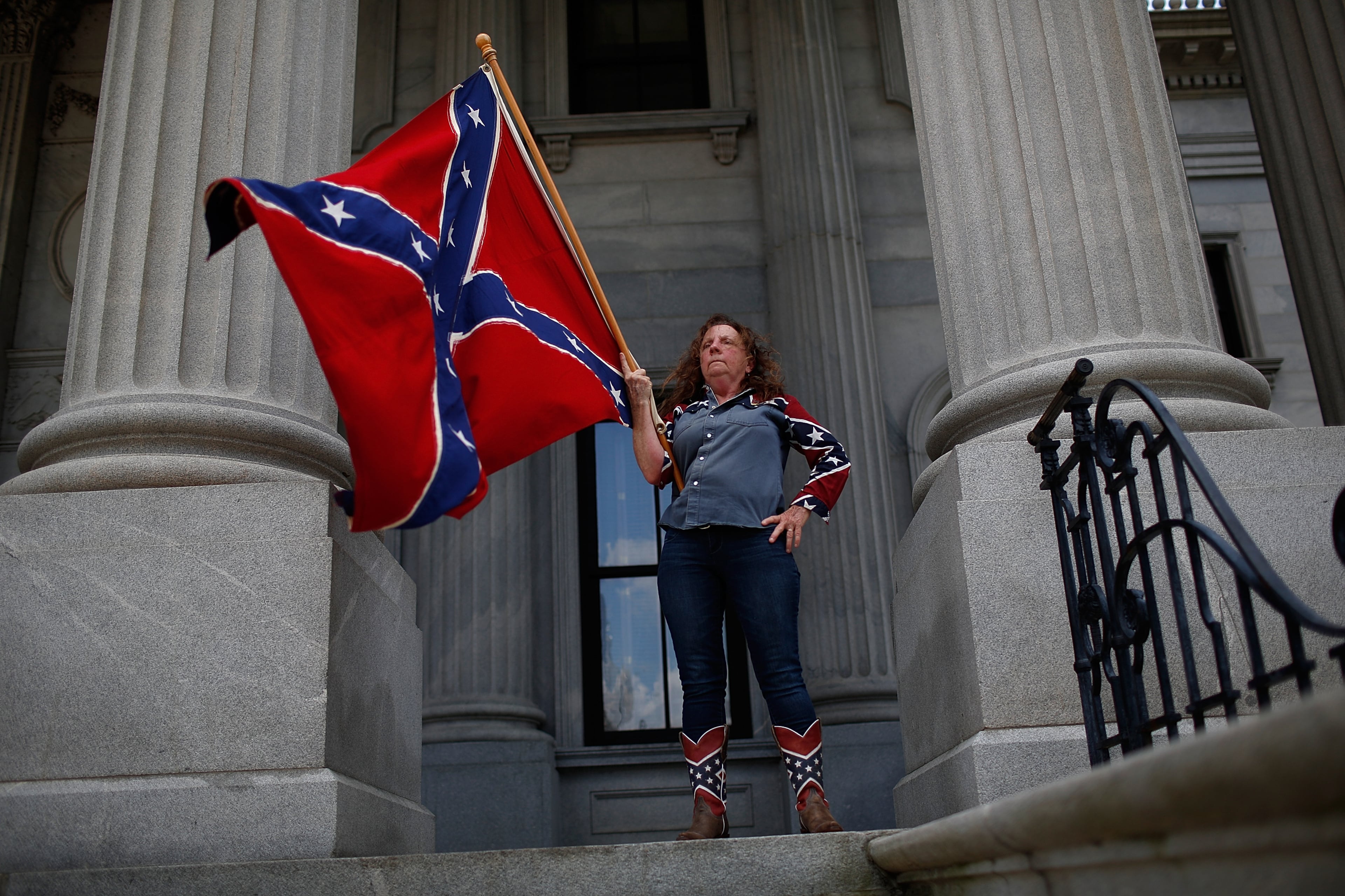 COLUMBIA, SC - JUNE 27: Alice Dixie Horky, of Greenville, South Carolina joins a group of demonstrators on the steps of the South Carolina State House calling for the Confederate flag to remain on the State House grounds June 27, 2015 in Columbia, South Carolina. Earlier in the week South Carolina Gov. Nikki Haley expressed support for removing the Confederate flag from the State House grounds in the wake of the nine murders at Mother Emanuel A.M.E. Church in Charleston, South Carolina. (Photo by Win McNamee/Getty Images) *** BESTPIX ***