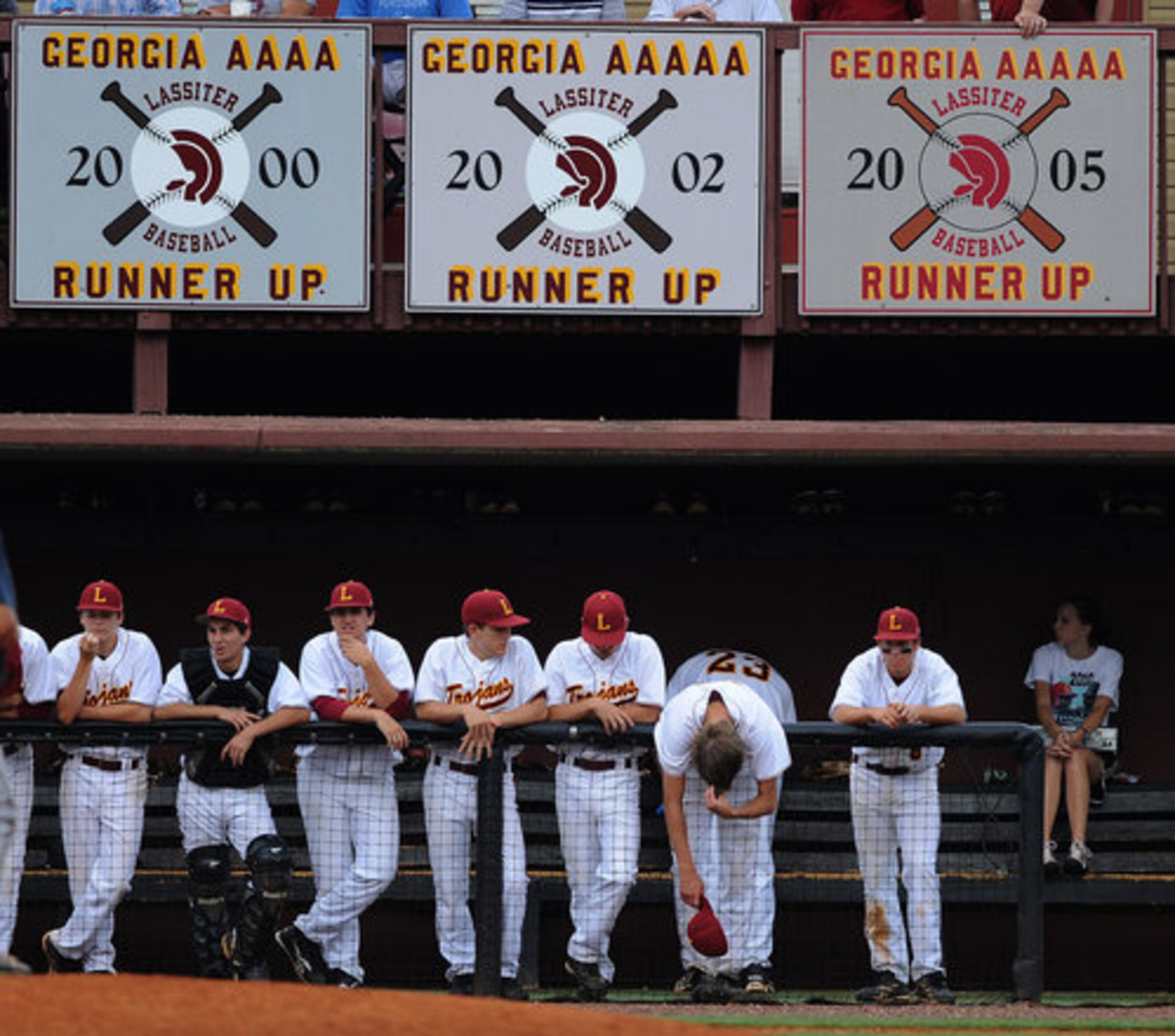 Members of the Lassiter High School baseball team stand below runner up banners in the 6th inning during game 1 for the Class AAAAA baseball championship.