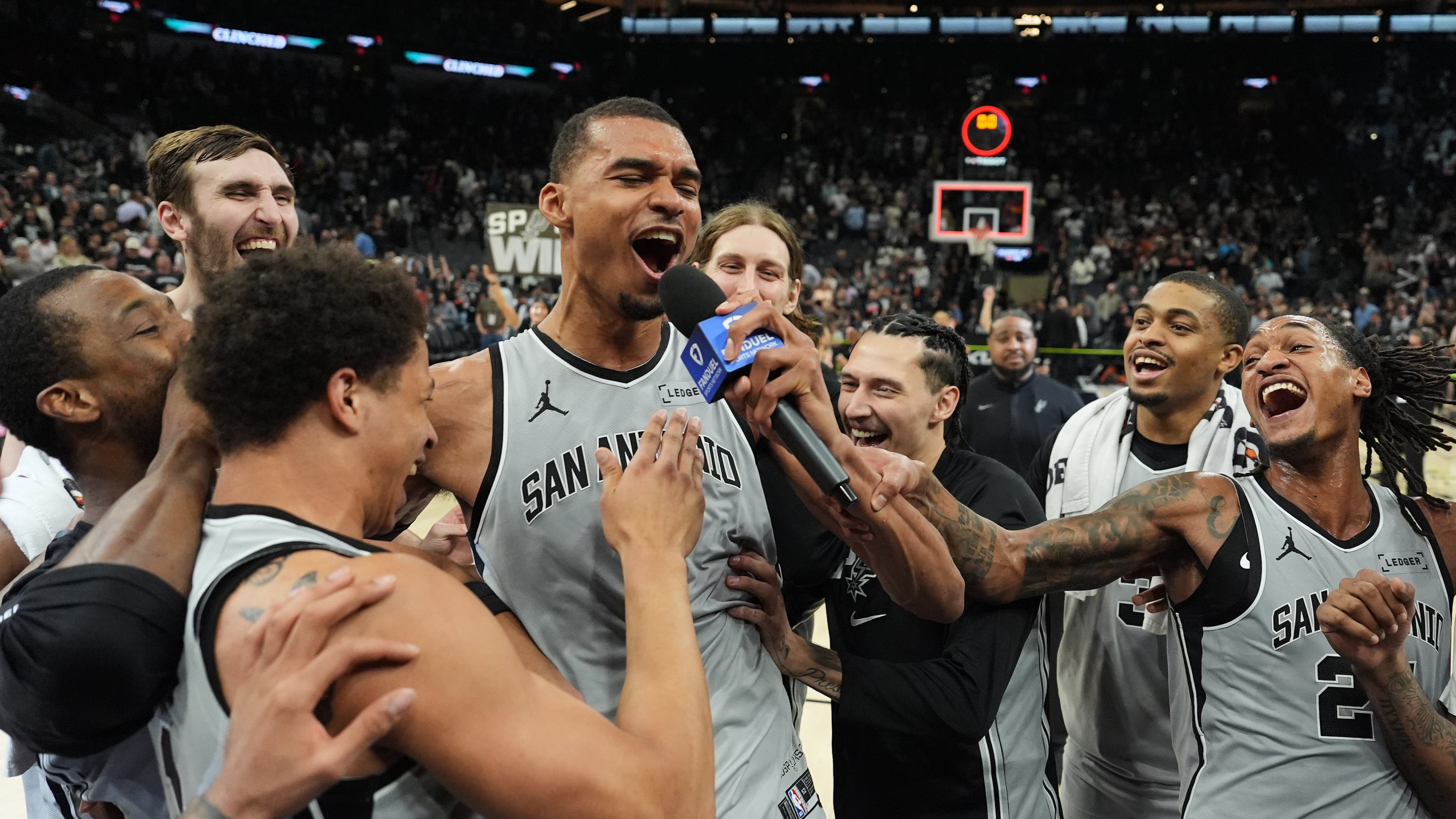 San Antonio Spurs forward Victor Wembanyama, center, celebrates with teammates after he hit a game-winning score against the Phoenix Suns in the final seconds of an NBA basketball game in San Antonio, Thursday, March 19, 2026. (AP Photo/Eric Gay)