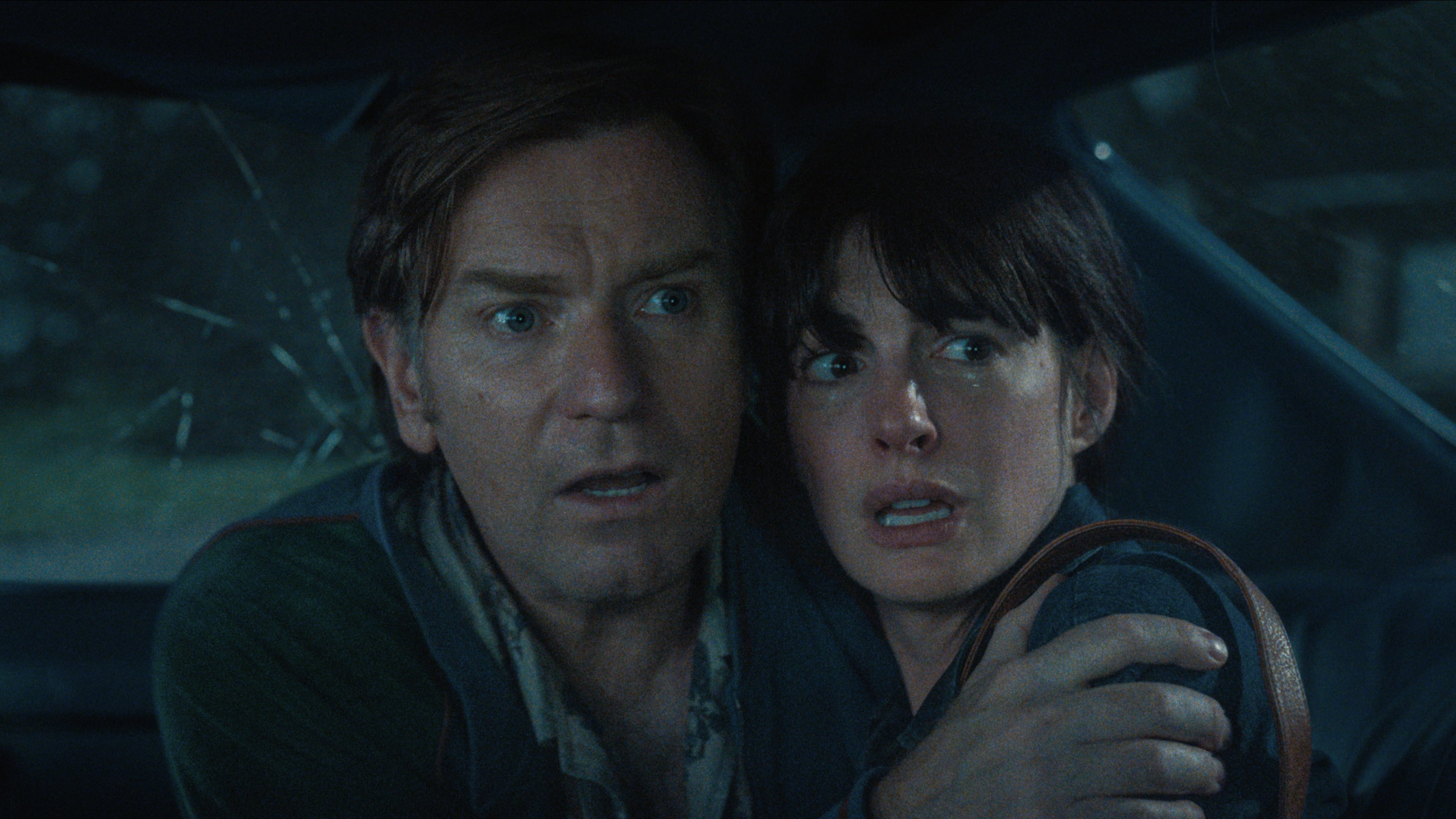 Ewan McGregor and Anne Hathaway inside a car trying to avoid a dinosaur in the sci-fi adventure "The End of Oak Street" shot in the Wisteria Gardens neighborhood of Southwest Atlanta in 2024. (Courtesy of Warner Brothers)