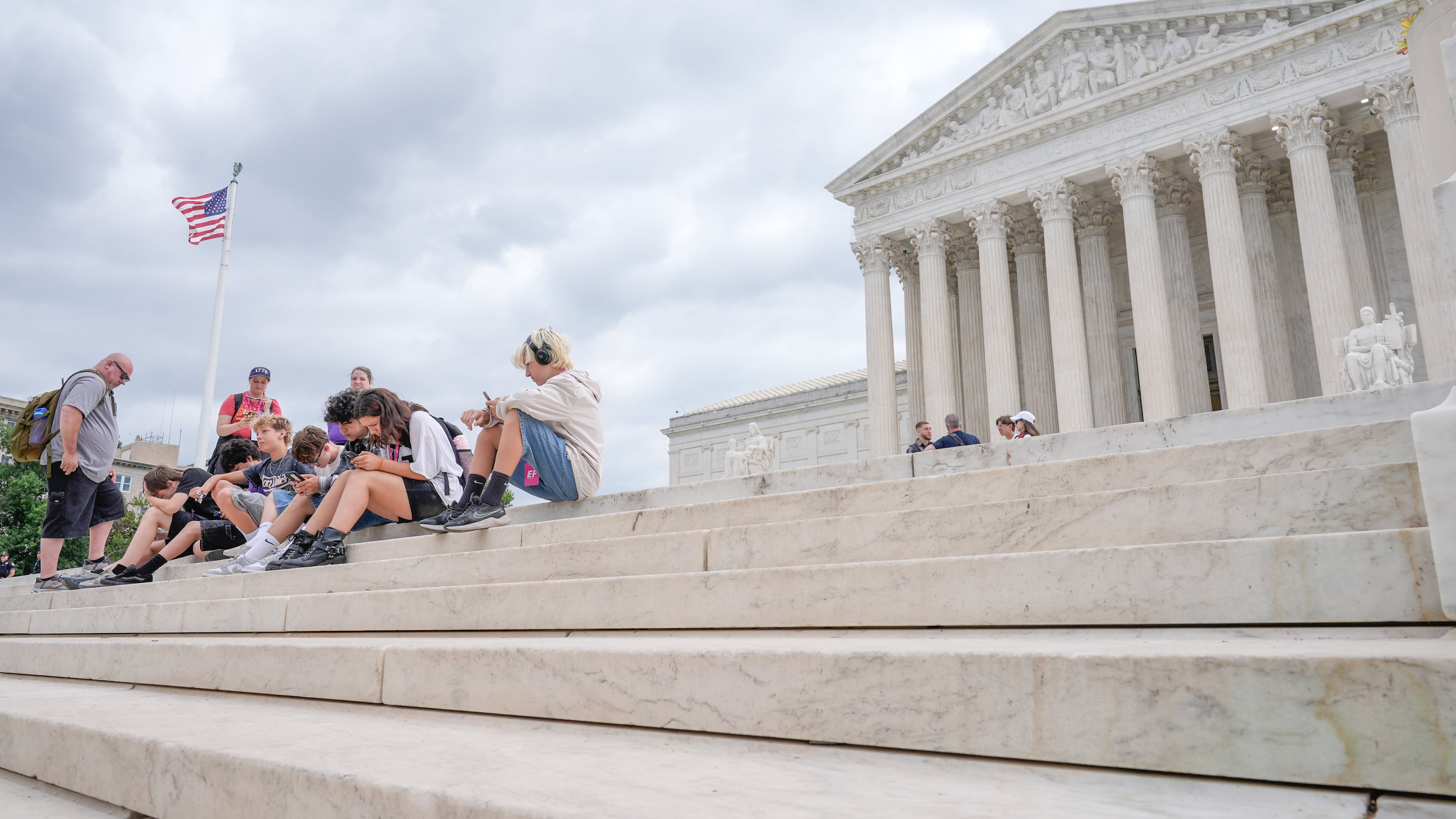 Visitors sit on the steps of the U.S. Supreme Court, Monday, June 8, 2026, in Washington. (AP Photo/Mariam Zuhaib)
