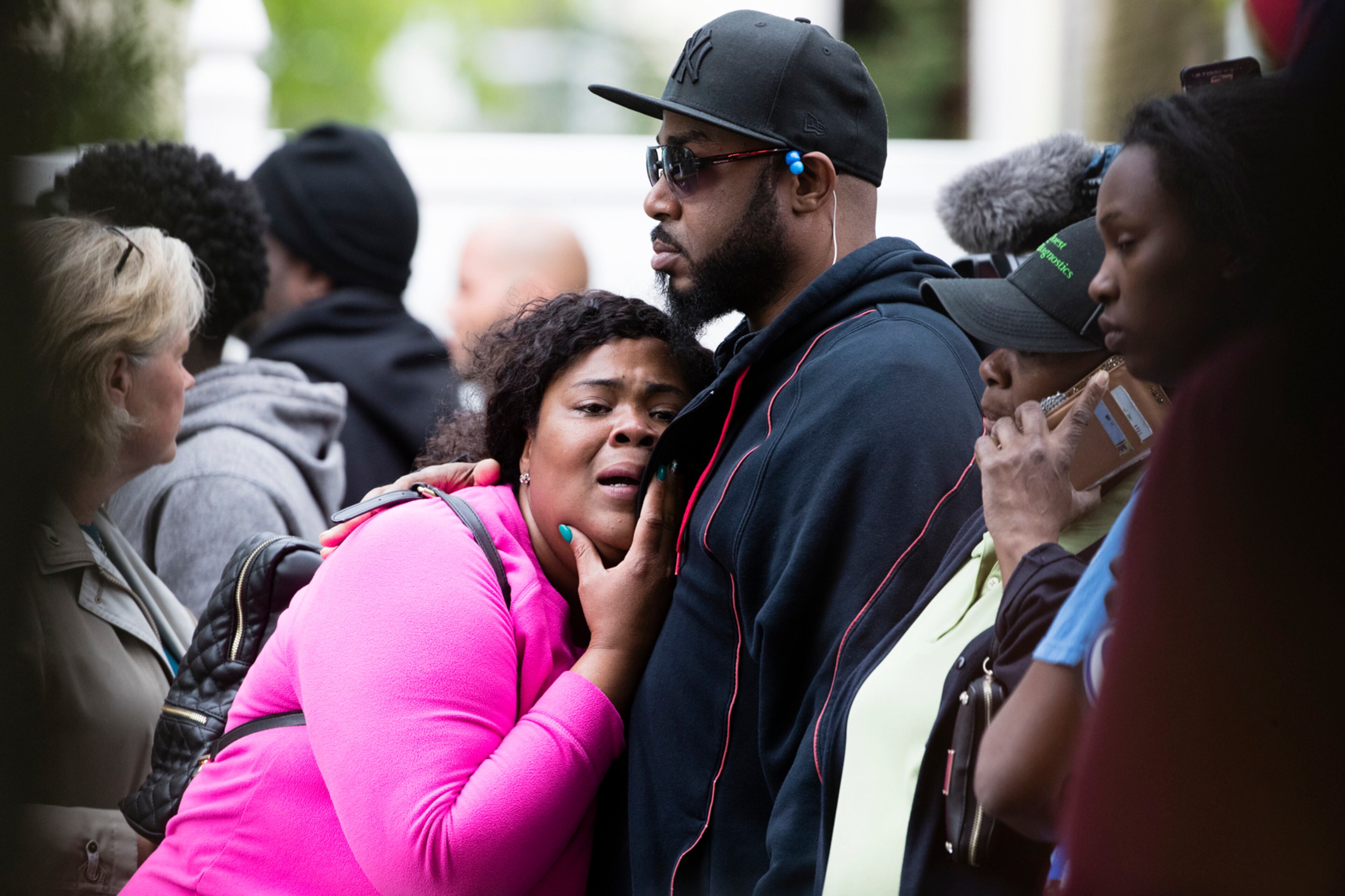 In this Wednesday, May 10, 2017 photo people react during a standoff between police and a man in a home in Trenton, N.J. Police said they are trying to negotiate with the suspect after a fatal gunfire exchange with police. (AP Photo/Matt Rourke)
