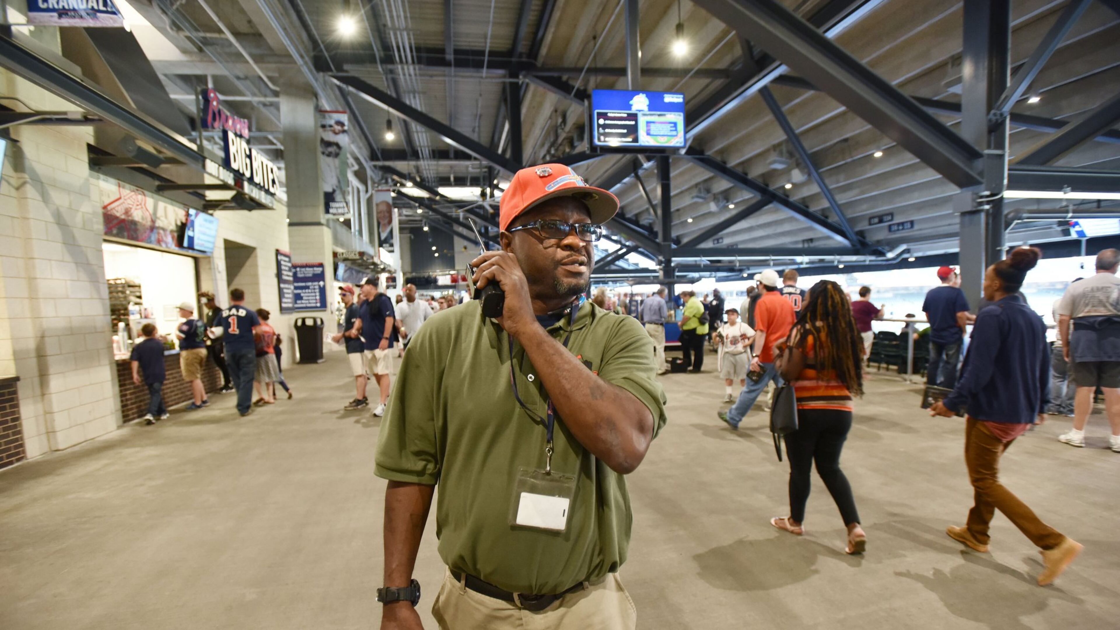 Darnell Wood uses a two-way radio to communicate with other staff before an Atlanta Braves home game against the Miami Marlins at SunTrust Park. Wood is getting back on his feet thanks to First Step Staffing, a nonprofit agency that has helped him get a job. First Step Staffing, which works to find jobs for homeless men and women, is partnering this season with the Atlanta Braves. HYOSUB SHIN / HSHIN@AJC.COM