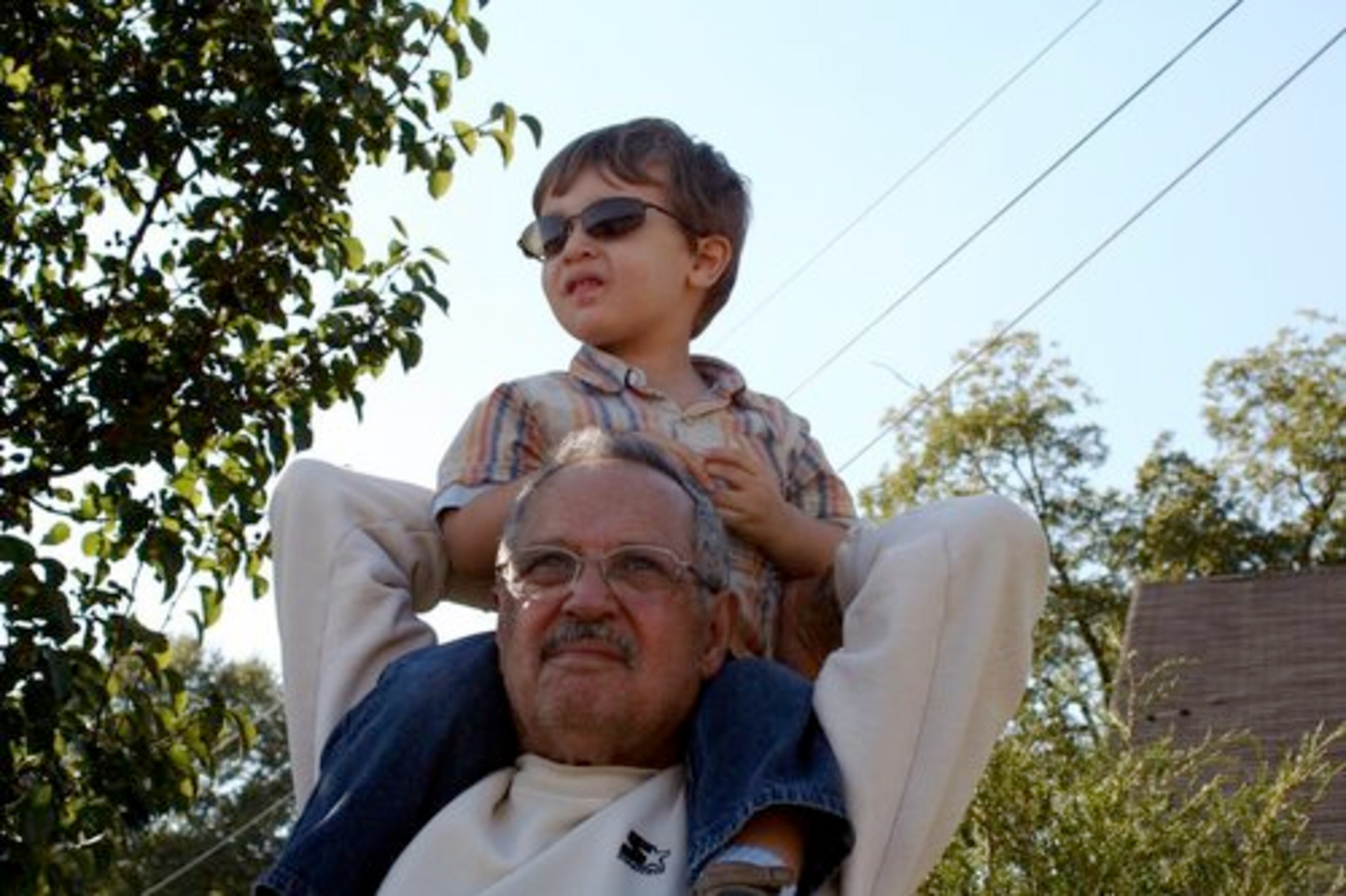 Caleb Breb n is enjoying the planes while sitting on Papi's shoulders (Grandpa William Breb n).