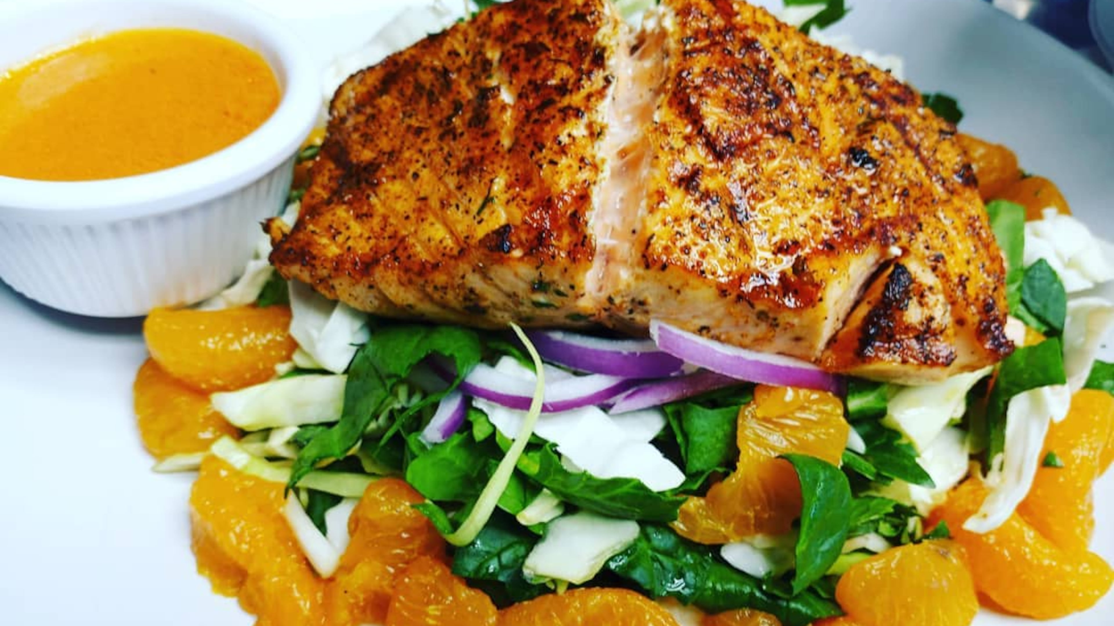 Grilled Norwegian salmon salad with blood orange dressing from the menu of Corner Grille. / Corner Grille Facebook page