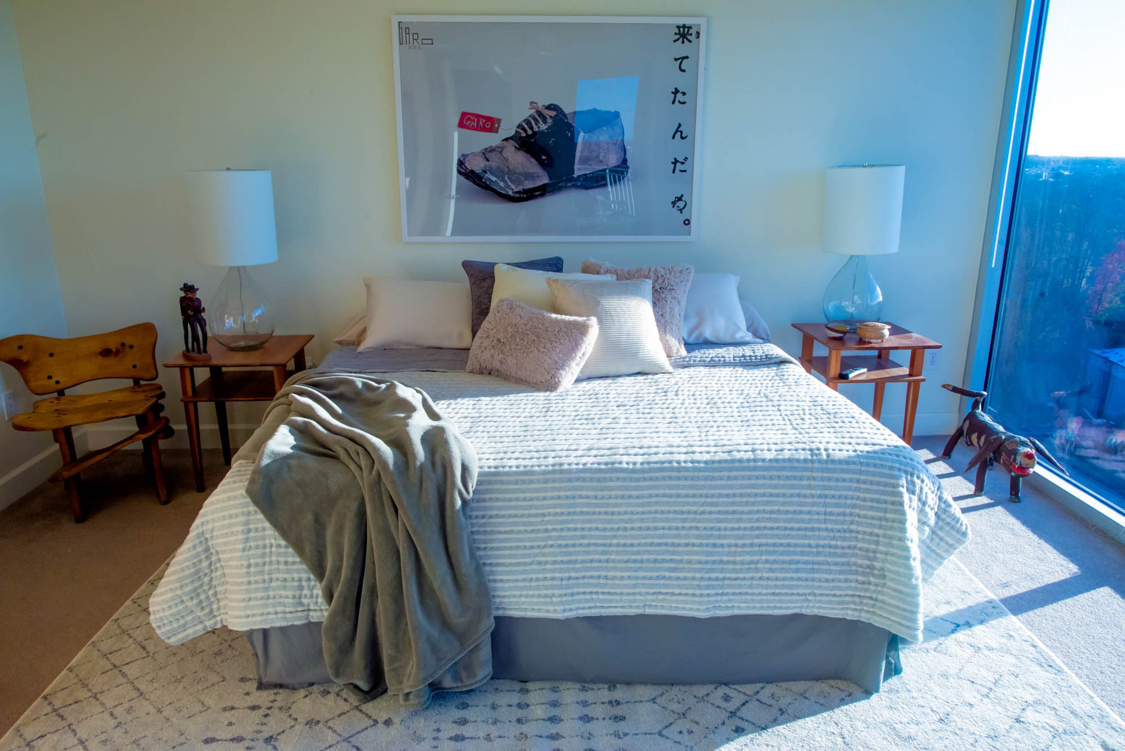 The master bedroom overlooks the city and features pieces with special meaning, whether it was hand carved by homeowner Ron Seichrist, made by a student or found at an art show. The lamps on either side of the bed are from RH. Text by Anna Logan/Fast Copy News Service.