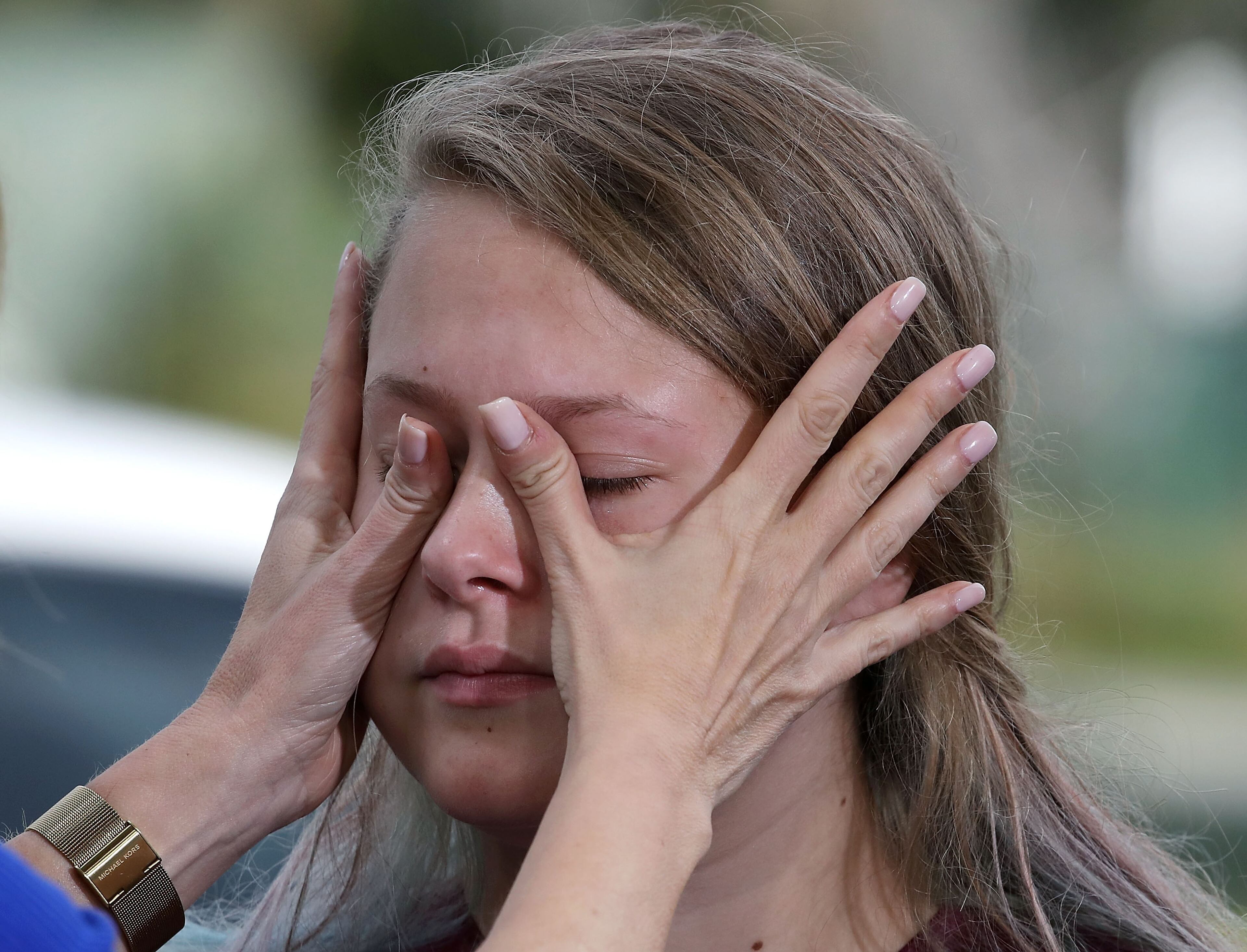 PARKLAND, FL - FEBRUARY 15: Student Kelsey Friend, gets help wiping away her tears after recounting her story about yesterday's mass shooting at the Marjory Stoneman Douglas High School where 17 people were killed, on February 15, 2018 in Parkland, Florida. Police arrested the suspect after a short manhunt, and have identified him as 19 year old former student Nikolas Cruz. (Photo by Mark Wilson/Getty Images)