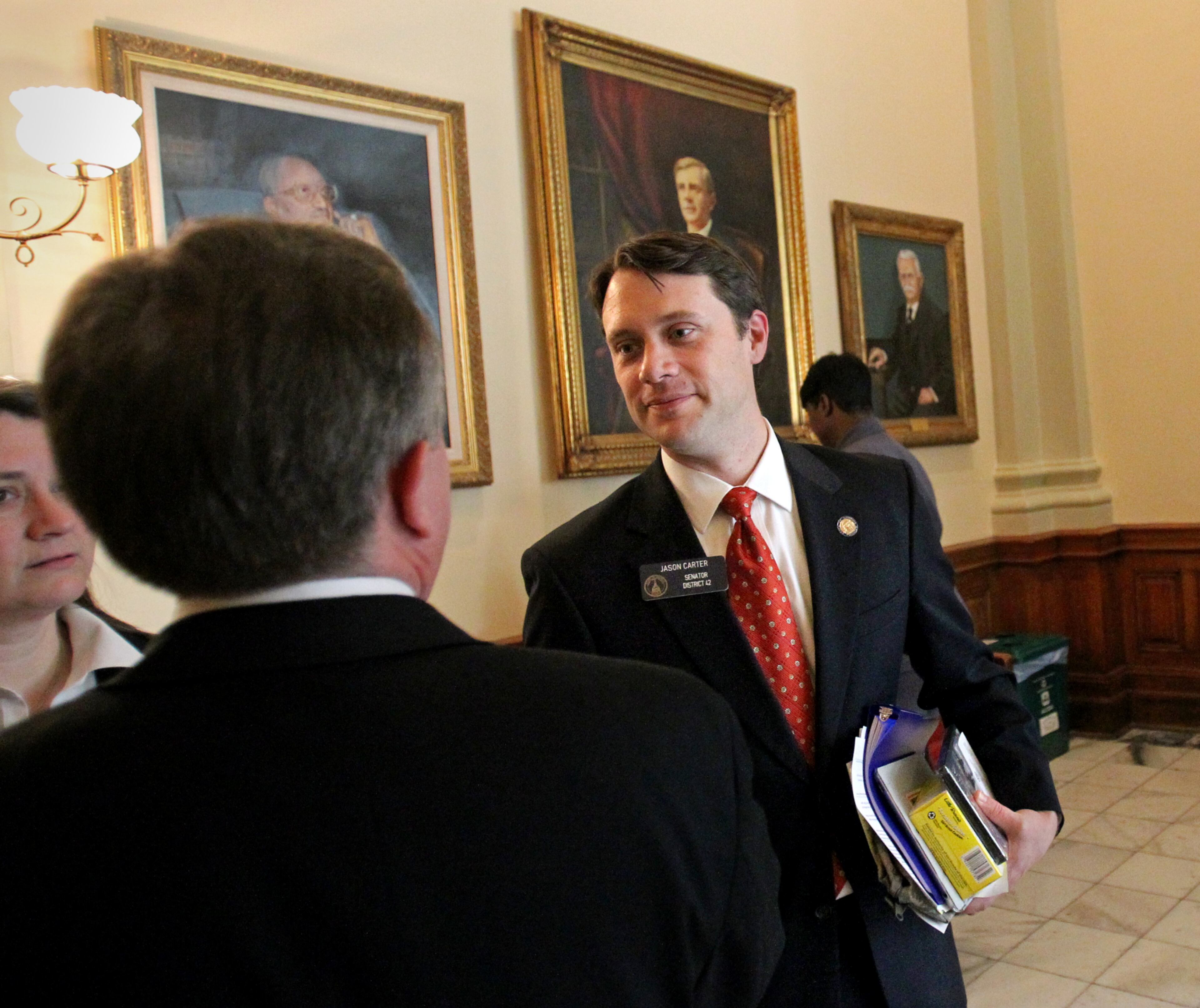 Sen. Jason Carter, D-Decatur, center, talks with Sen. Doug Stoner, D-Smyrna, in the hallways after a morning session in the Senate Chambers on Feb. 7, 2012.