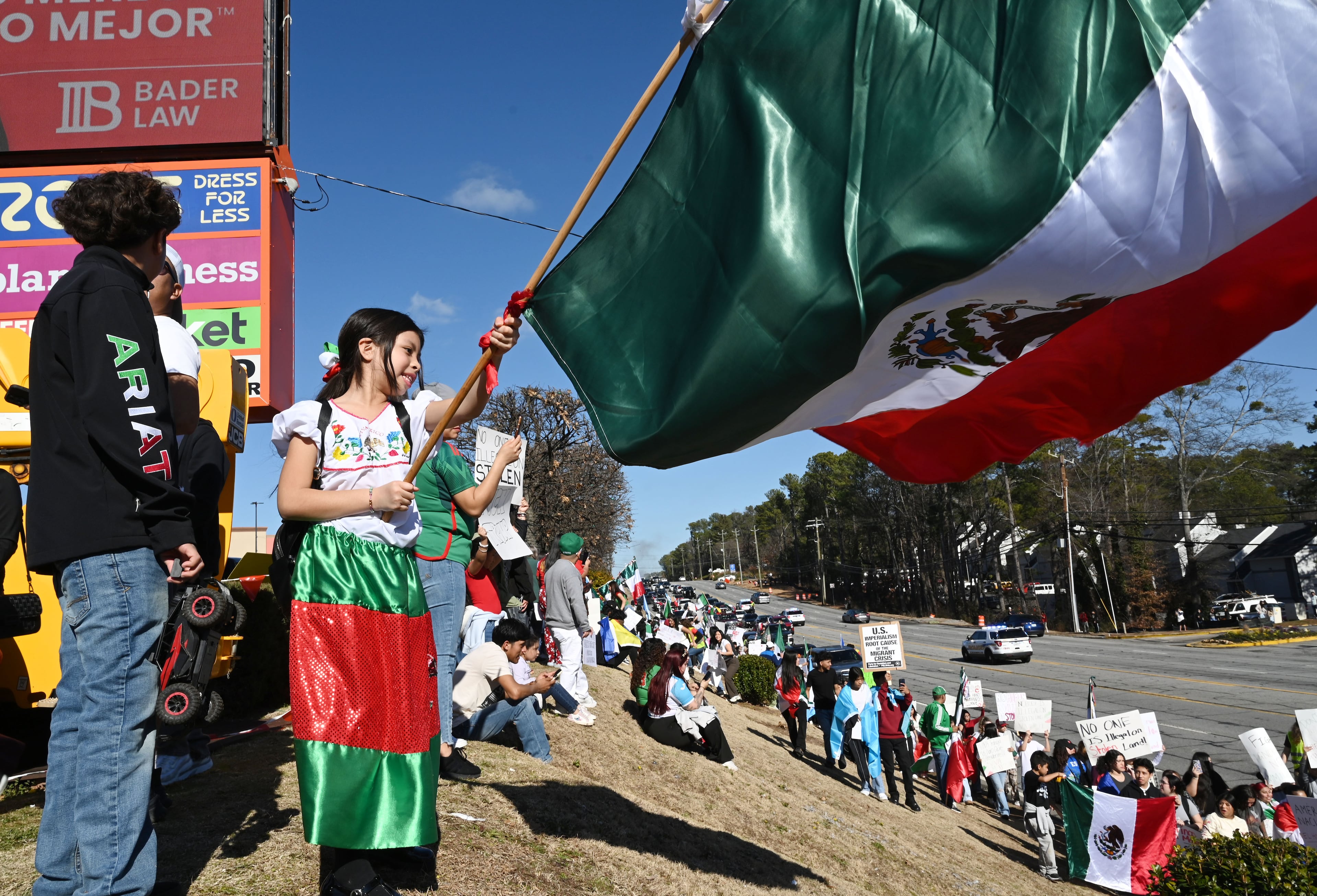 Pro-immigration protesters wave flags from Mexico, Cuba, Guatemala and Puerto Rico, and carrying signs condemning deportations along both sides of the corridor in front of Plaza Fiesta, Saturday, February 1, 2025, in Atlanta. About 1,000 protesters on Saturday gathered along Buford Highway, the immigrant hub of metro Atlanta, to call for an end to the targeted operations by immigration agents that began last week. (Hyosub Shin / AJC)