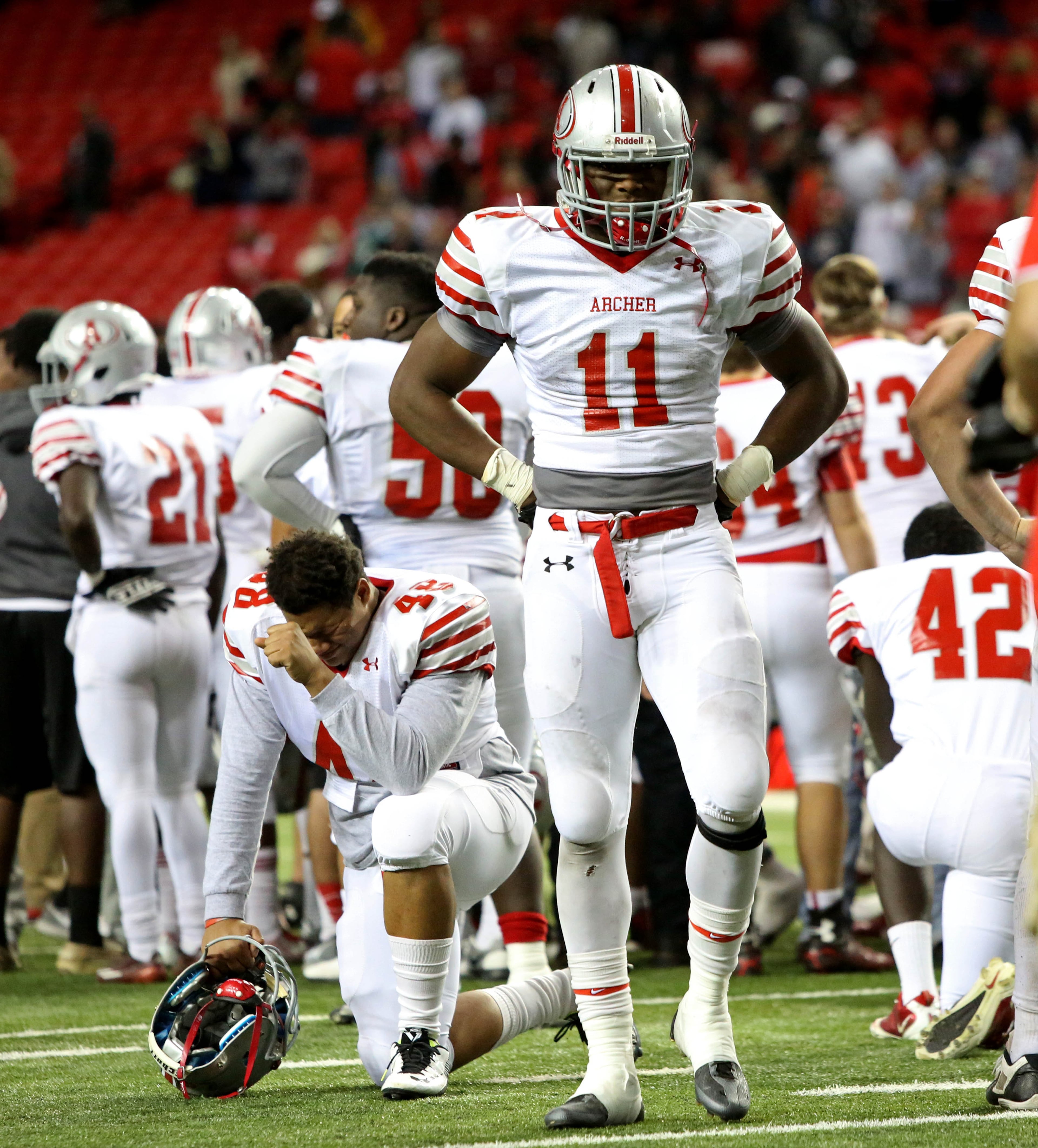 Archer linebacker Karmoni Williams (48) and wide receiver Kyle Davis (11) react after their loss to Colquitt County in the Class AAAAAA state high school football championship at the Georgia Dome Saturday in Atlanta, Ga., December 13, 2014. Colquitt County won 28-24.