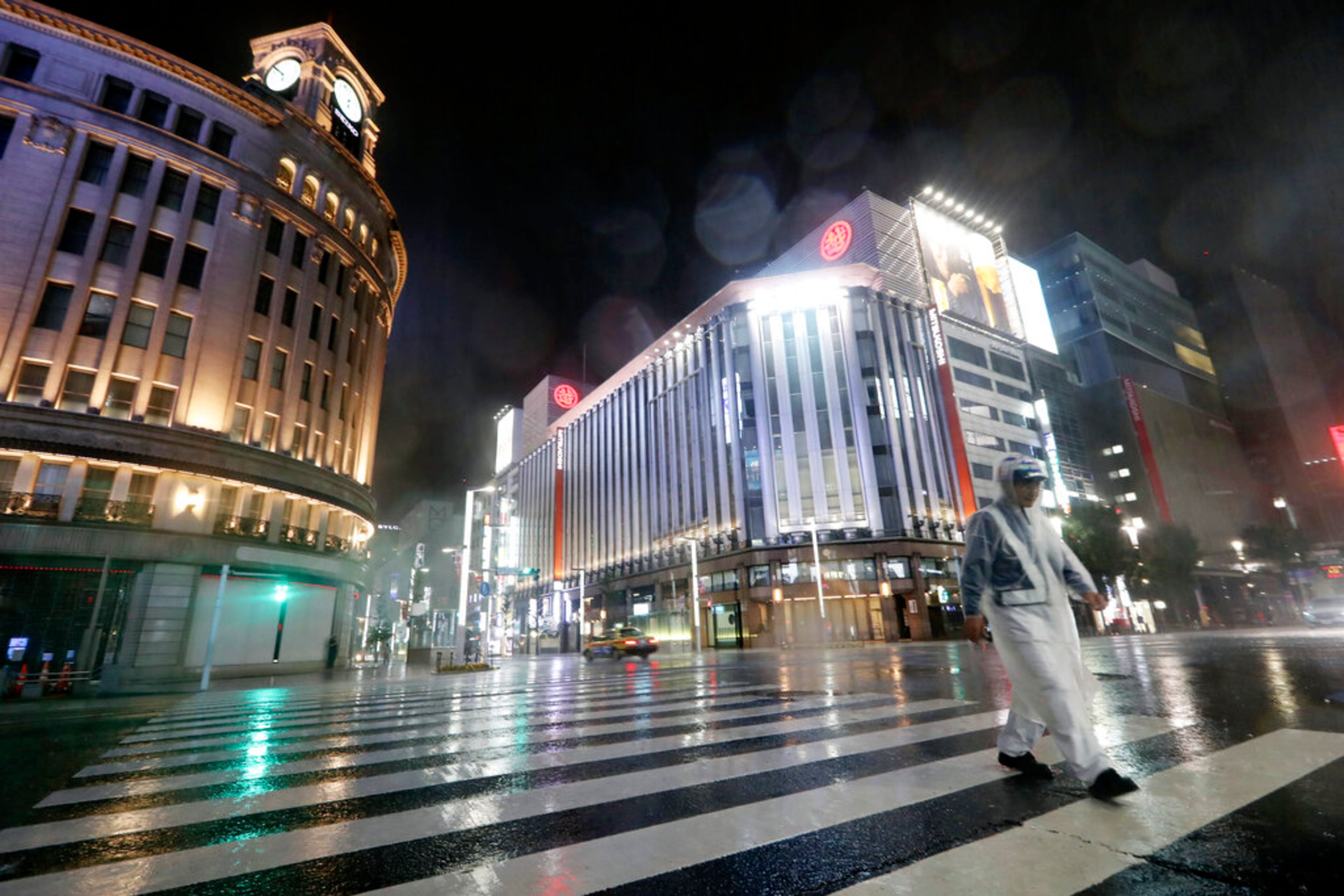 A security guard walks a pedestrian crossing at Ginza shopping district in the pouring rain due to Typhoon Hagibis in Tokyo Saturday, Oct. 12, 2019. A heavy downpour and strong winds pounded Tokyo and surrounding areas on Saturday as a powerful typhoon forecast as the worst in six decades approached landfall, with streets and train stations deserted and shops shuttered. (AP Photo/Eugene Hoshiko)
