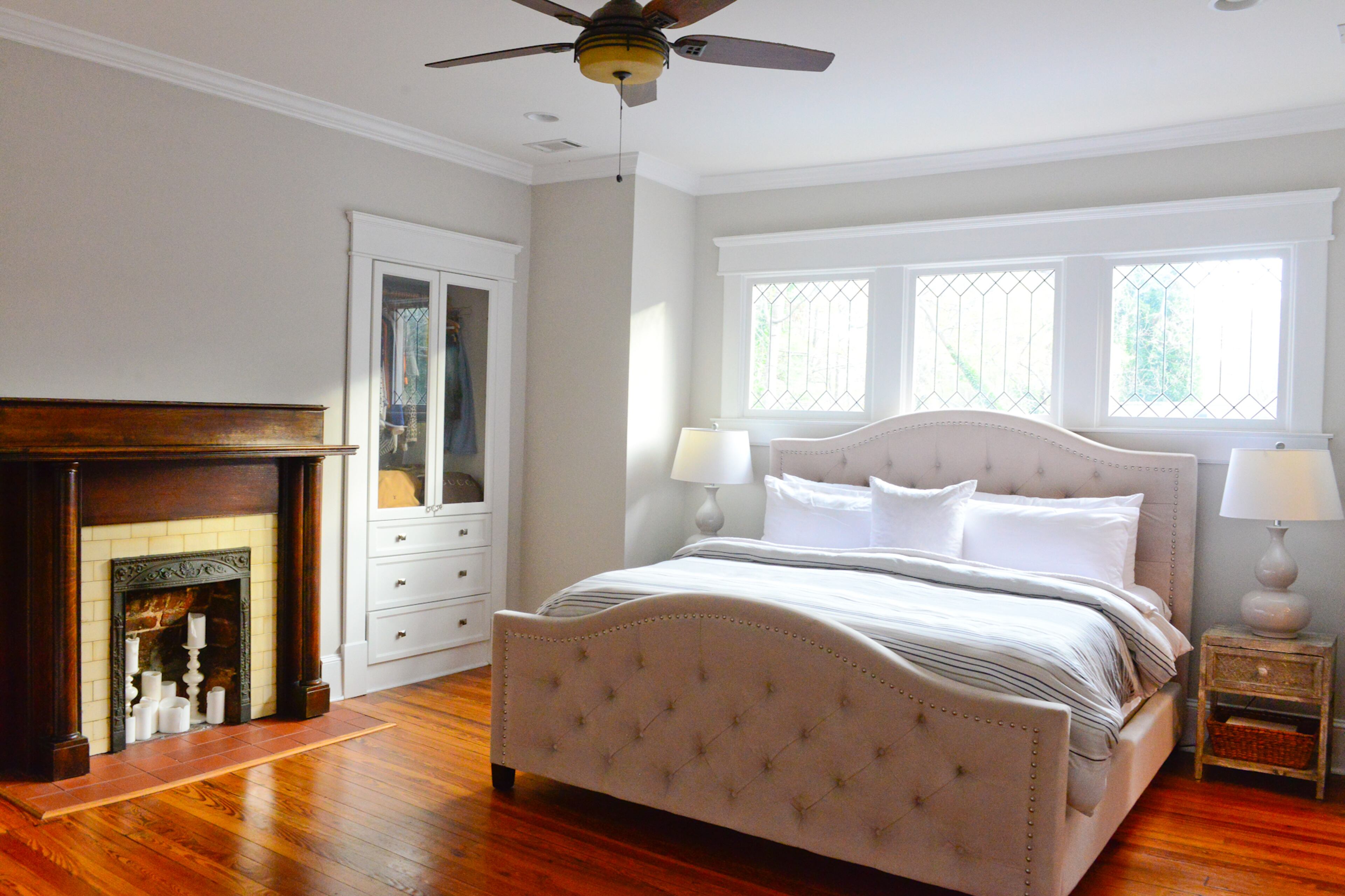 Above the master bed sit three beveled windows. Beside the bed from Z Gallerie, a wardrobe and set of drawers are set flush into the wall, giving needed storage without compromising space. The bedside tables were purchased from At Home.