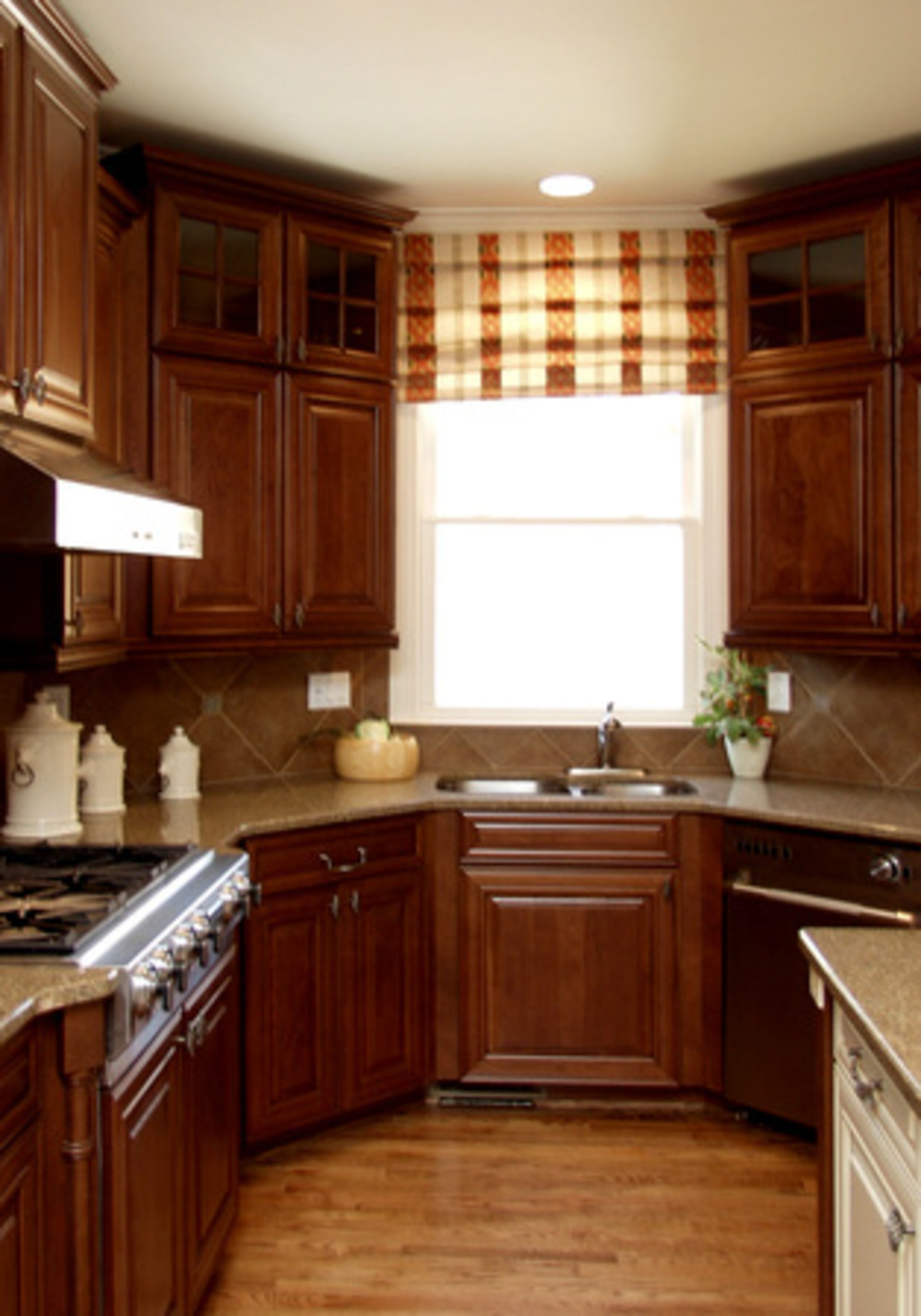 KITCHEN: An efficiently organized perimeter and large island, all topped with granite, provide plenty of work and storage space in the open kitchen. Raised-panel cherry cabinets with brushed pewter hardware set off the stainless steel sink and appliances.