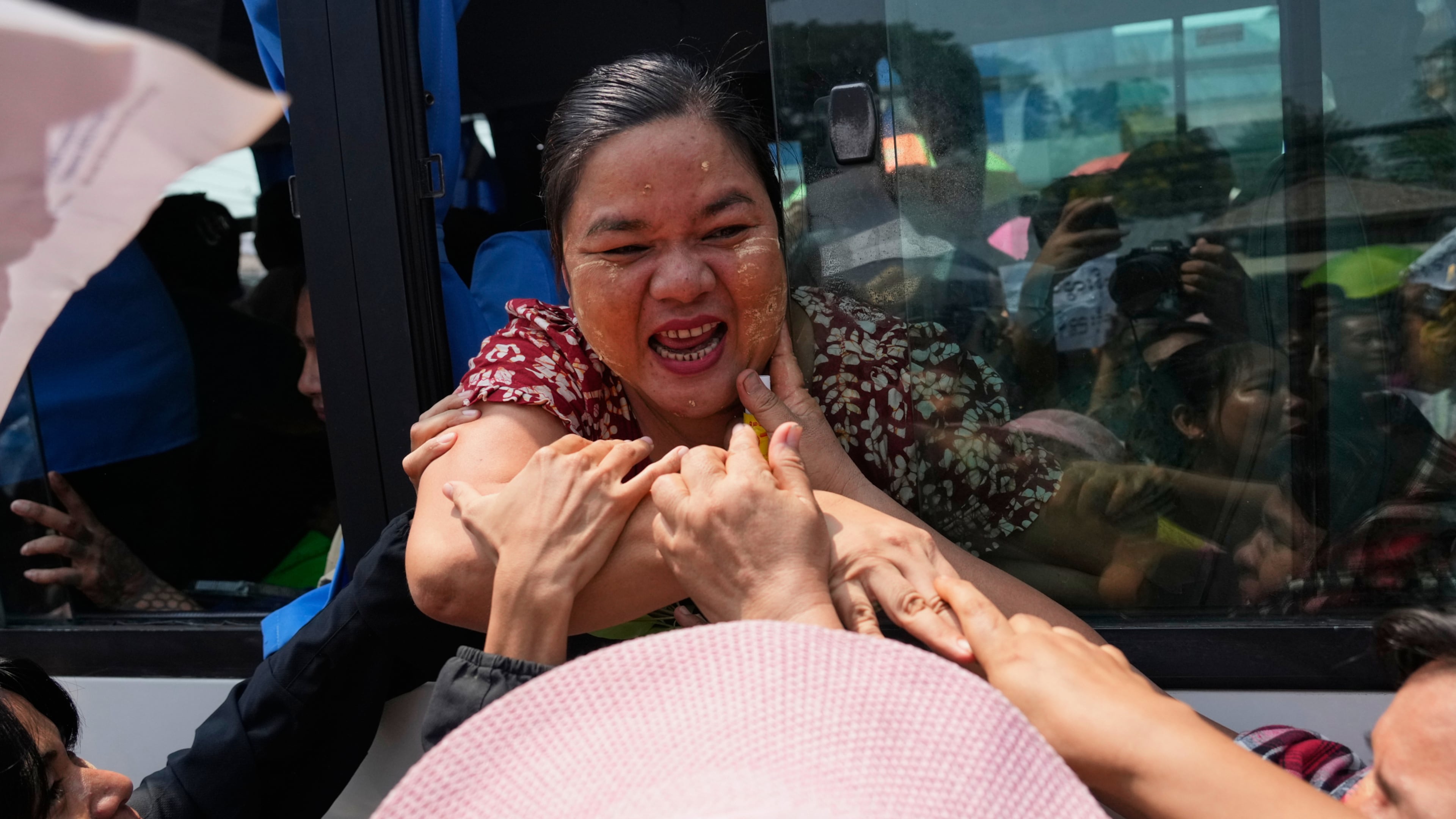 Released prisoners, in a bus, are welcomed by family members and colleagues after they left Insein Prison in Yangon, Myanmar, Friday, April 17, 2026, following Myanmar President's amnesty to mark the country's traditional new year. (AP Photo/Thein Zaw)