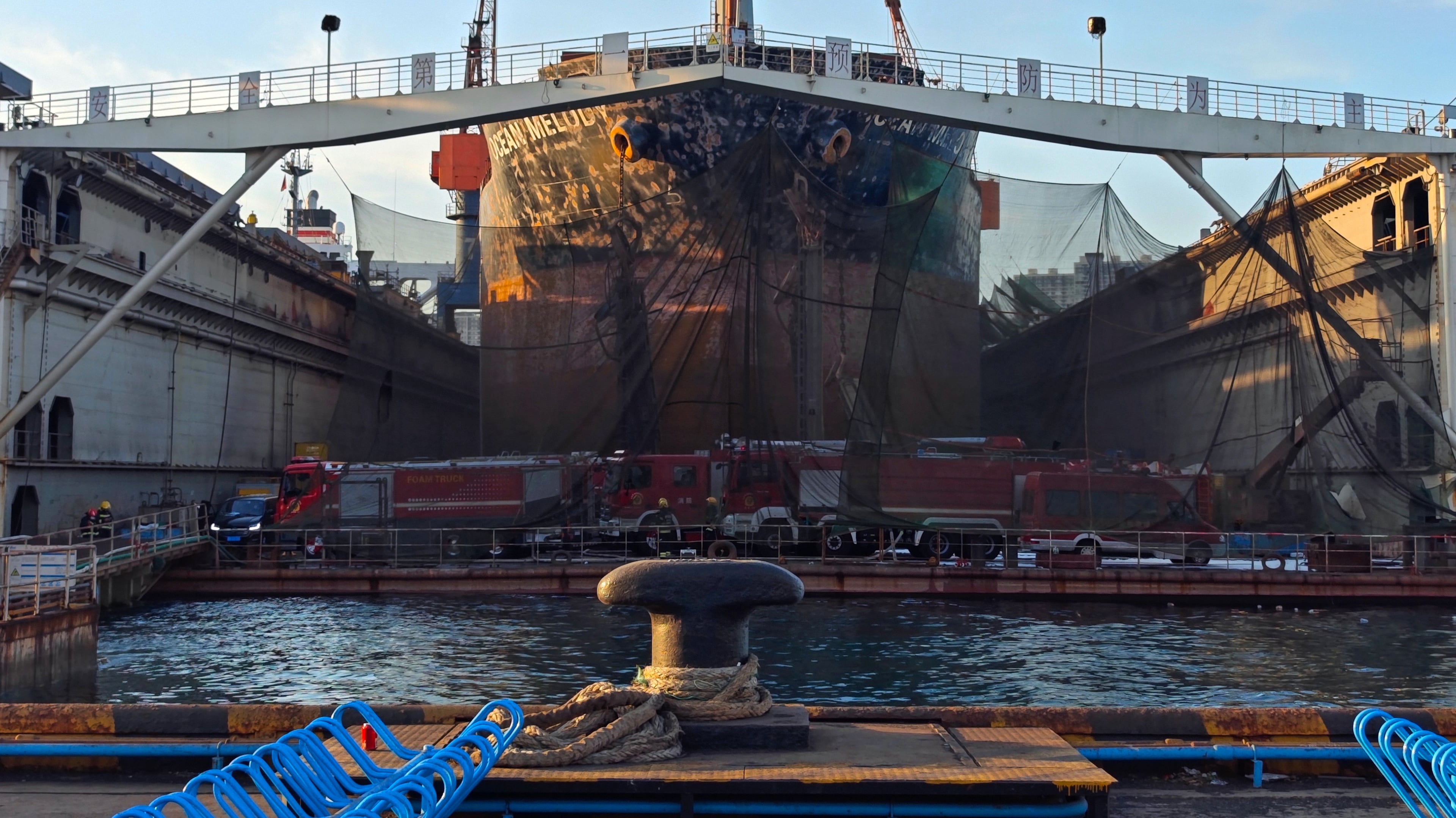 In this photo released by Xinhua News Agency, firefighters' vehicles parked near a repair cargo ship after it caught fire at a port in Qingdao, east China's Shandong Province, Thursday, Sept. 10, 2026. (Li Aoqiu/Xinhua via AP)