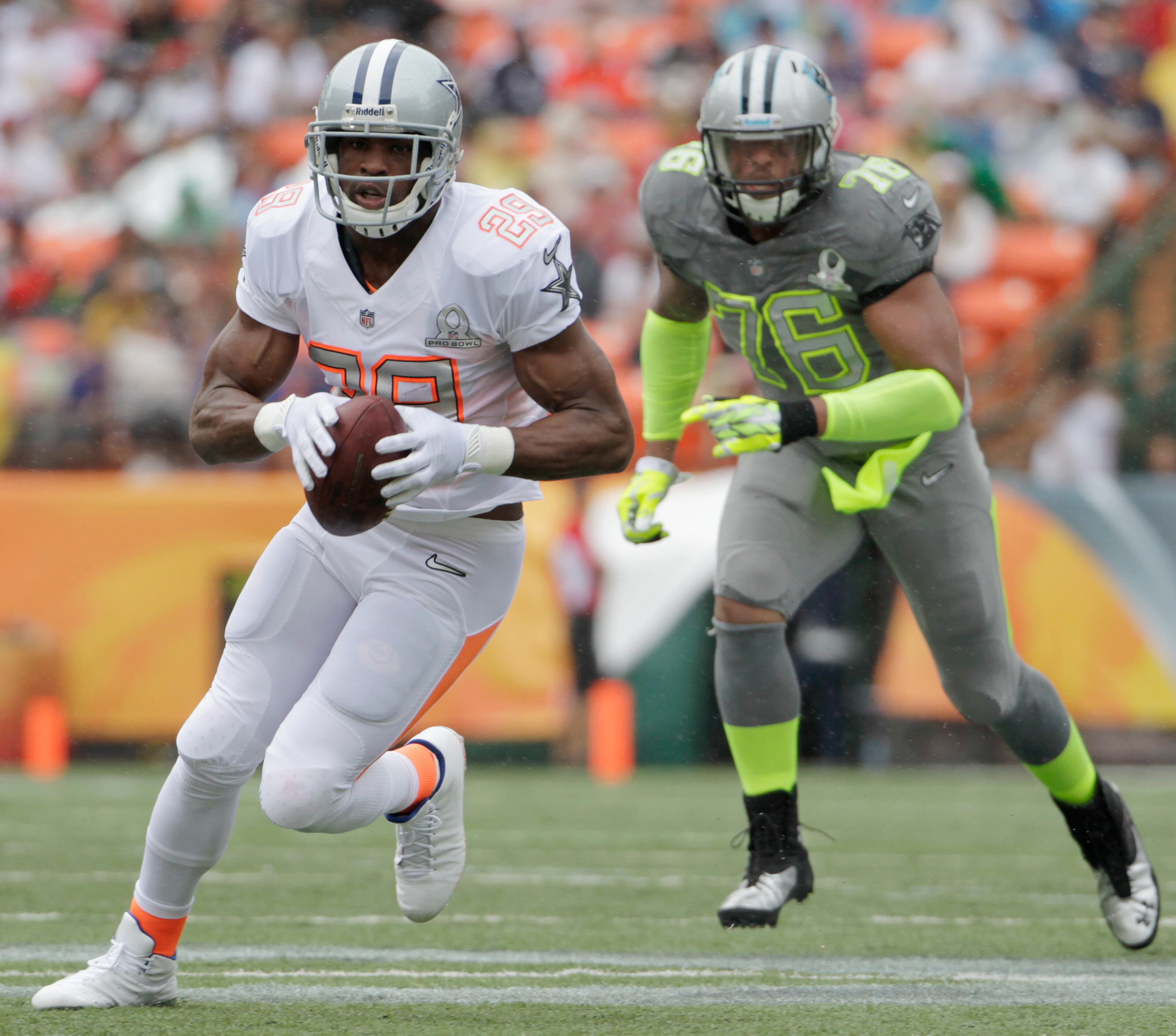 Dallas Cowboys running back DeMarco Murray (29) of Team Rice runs with the football after catching a pass in the first quarter quarter of the NFL Pro Bowl football game Sunday, Jan. 26, 2014, in Honolulu. Carolina Panthers defensive end Greg Hardy (76) of Team Sanders looks on during the play. (AP Photo/Eugene Tanner)