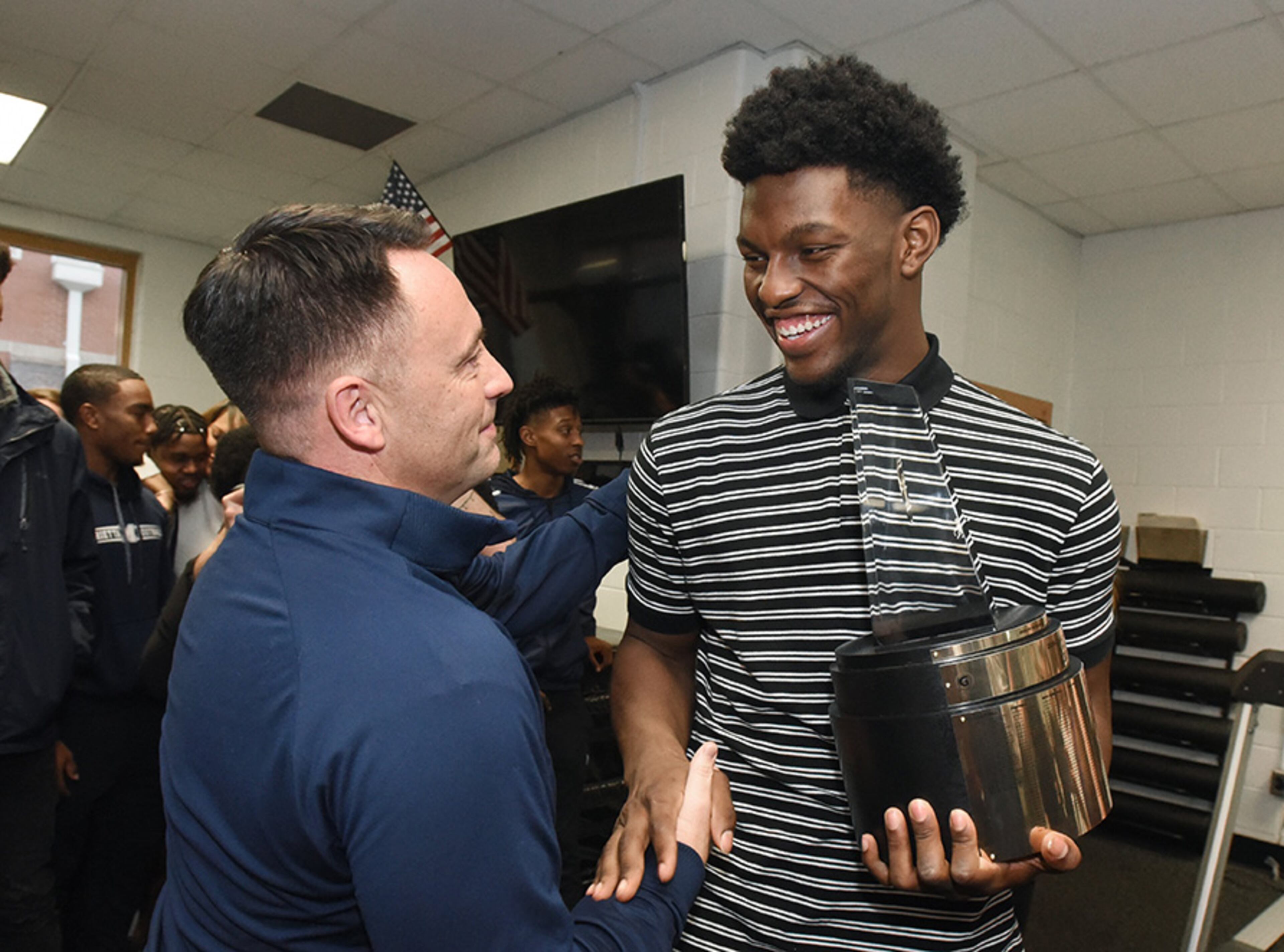 Marietta football coach Rich Morgan (left) congratulates Marietta tight end Arik Gilbert as he holds the 2019-20 Gatorade National Football Player of the Year trophy Tuesday, Dec. 17, 2019, at Marietta High School in Marietta. The team won the Class AAAAAAA state title over Lowndes last week.