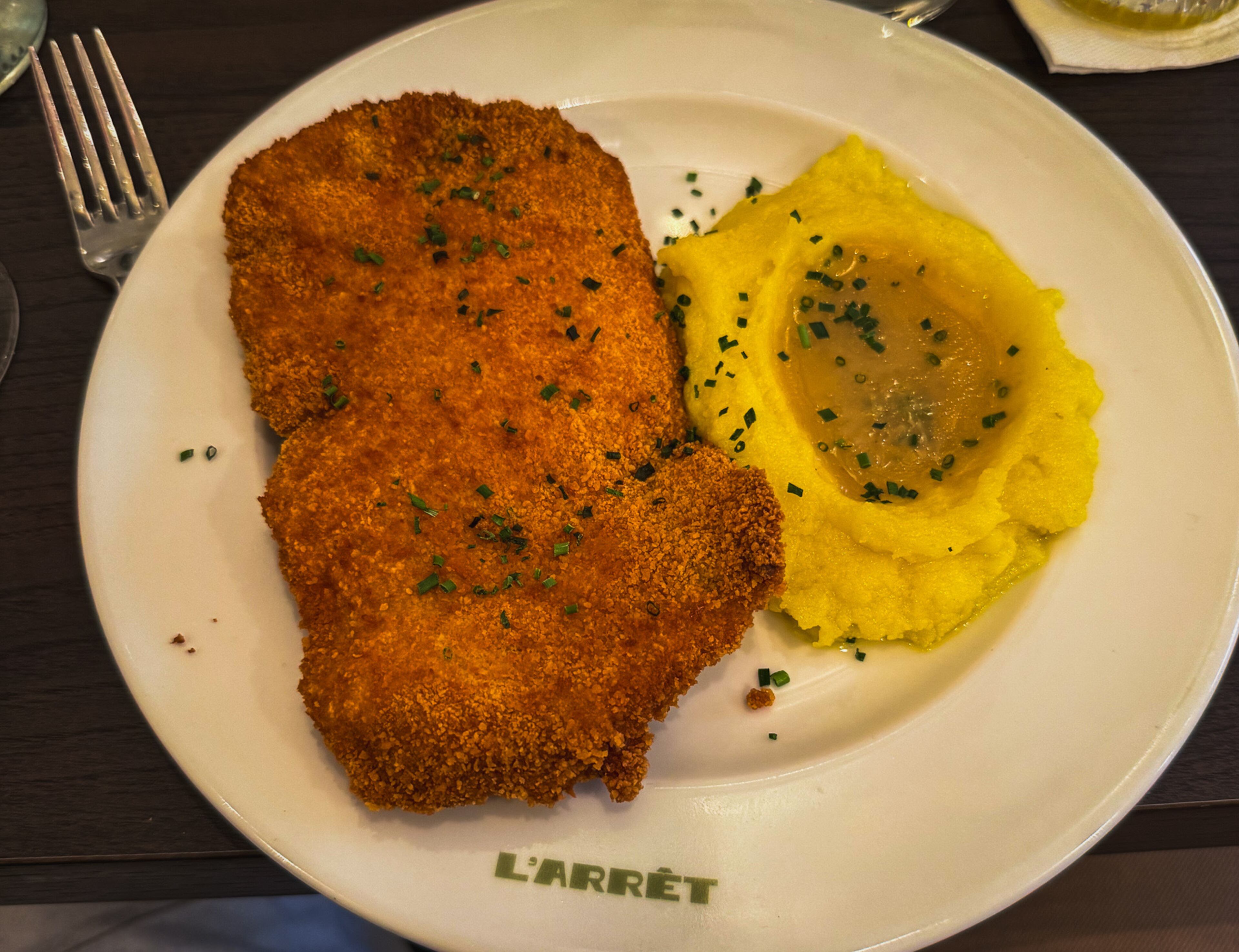 A Southern-style chicken schnitzel with mashed potatoes and gravy at L'Arret by the Grey in Paris. (Henri Hollis/AJC)